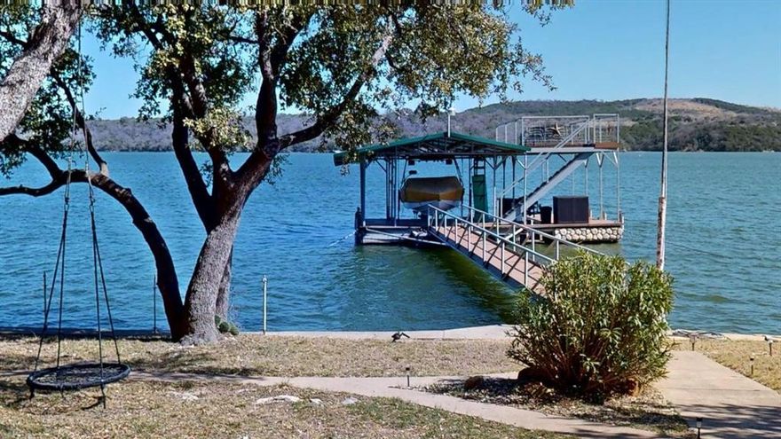 Lakefront property with a covered dock. Quiet and secluded Caddo Creek. Mobile home converted to a lakeside cabin. Wood siding with metal roof. Family room addition with wood burning fireplace. Detached bunk room sleeps 6. Covered carport for parking. Lake water pump with purification system. Sprinkler irrigation system. Boat house on shore. Covered dock built in 2018 with boat lift in 30 feet of water. Terraced lawn has an amazing view of the lake and beyond.