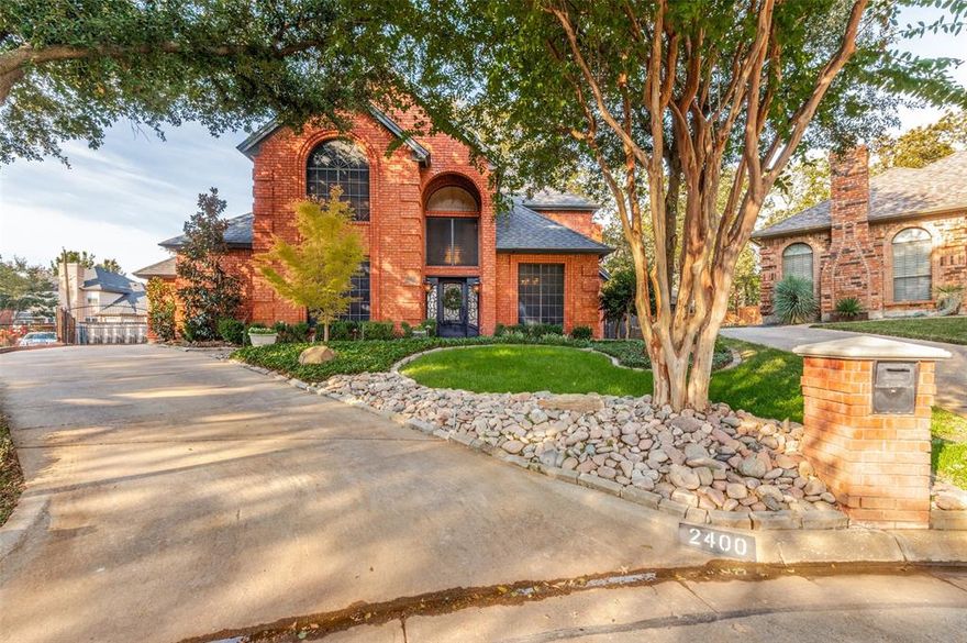 This impressive, low-maintenance home offers spacious, bright interiors perfect for entertaining. Nestled on a quiet cul-de-sac in north Arlington, the property provides a peaceful oasis while still being close to the Arlington entertainment district and convenient routes throughout the DFW area. The home spans 2,554 square feet and features a desirable open floor plan with elegant plantation shutters and tile and hardwood flooring. The family room includes a striking wood-burning brick fireplace and opens directly into a large, eat-in kitchen equipped with granite countertops, an island, ample cabinetry, and beautiful custom lighting. An additional first-floor living space comes with a built-in bar, making it ideal as an entertainment room or study. With three generously sized bedrooms and two and half baths, the private master suite is located on the first floor and includes a spa-like bath with dual vanities, separate tub and shower, and a large walk-in closet. Upstairs, you'll find a built-in desk with cabinets on the landing, plus the remaining two bedrooms and another bathroom. Outside, the backyard boasts a covered patio and a stunning pool with an attached spa—perfect for relaxing or hosting gatherings during the hot summer months. The driveway is secured by an access gate and is oversized to fit multiple vehicles comfortably. This home stands out for its fantastic location, attractive price, and array of desirable features. Furniture is also available and negotiable.