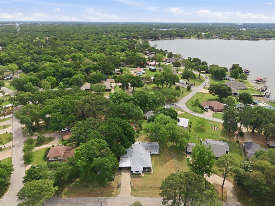 Welcome home to where lake living meets space, comfort, and memories ready to be made! Nestled on one acre with mature trees in the established Eastwood Island subdivision, 4-bedroom, 2-bath home offers incredible views of Cedar Creek Lake & access to community parks, fishing areas, & a convenient boat ramp—perfect for enjoying the lake lifestyle year-round. Inside, you’ll find the layout featuring two spacious living areas, ideal for entertaining guests or hosting memorable summer gatherings. Whether you’re relaxing w-family or celebrating special occasions, there’s room for everyone to spread out & enjoy. The kitchen is generously sized, offering plenty of space for preparing holiday meals, gathering w-loved ones, or enjoying a quiet morning coffee while taking in the peaceful surroundings.  The split-bedroom floor plan provides privacy & functionality, w-the primary suite featuring an ensuite bathroom and dual closet. The additional bedrooms are well-sized and versatile, perfect for guests, a home office, or hobbies. Step outside to a fenced yard with endless possibilities—plenty of room for outdoor activities, pets, or simply soaking in the stunning lake views. The property also includes both a garage and carport, providing ample parking and storage options including the building in the backyard. Located near the local golf course, shopping, dining, and countless outdoor activities, this home offers the perfect balance of relaxation & accessibility. Whether you’re looking for a full-time residence or a weekend getaway, this property delivers the charm & lifestyle Cedar Creek Lake is known for. Don’t miss your opportunity to own a slice of lake living!