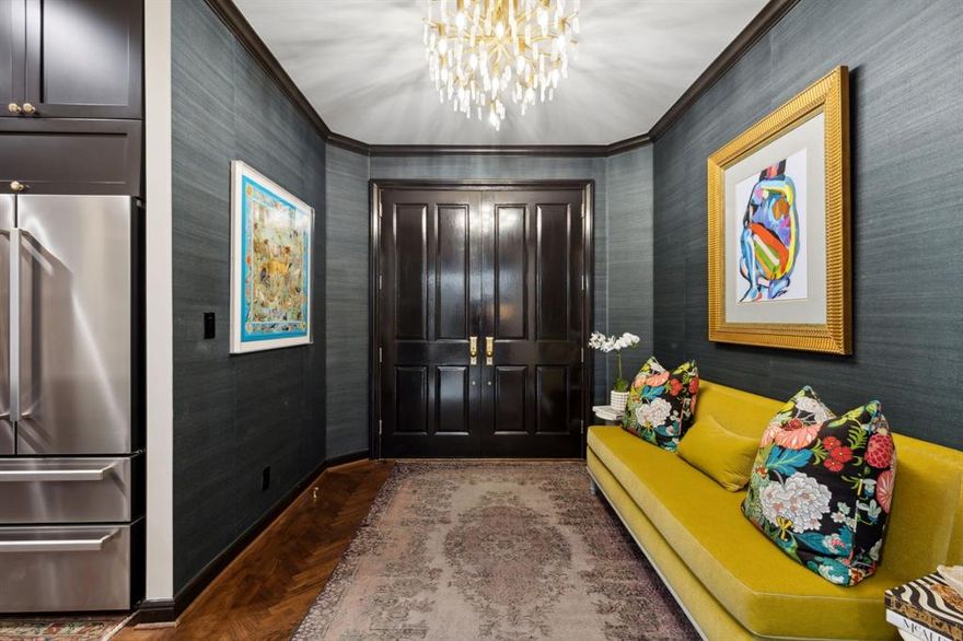 Tucked into the northeast corner of The Claridge, this fully renovated residence feels like a private retreat in the trees—overlooking the Katy Trail with serene, uninterrupted greenery from every window.

Spanning 2,020 square feet, the home was completely reimagined in 2020 with a focus on elevated design and effortless living. Light-filled interiors feature soaring 9’5” ceilings, warm hardwood floors, and a stunning custom fireplace framed in Cambria quartz.

Designed for both everyday living and entertaining, the open living space is complemented by a one-of-a-kind Palmer Industries brass and glass floating bar with dramatic python tile up the wall. The kitchen is equally impressive, featuring a Bertazzoni appliance suite, quartzite countertops, and a seamless full-height backsplash.

Every detail has been thoughtfully curated—from the marble bathrooms and custom black-paneled primary shower to the striking powder bath with lucite and brass finishes. A private balcony with Presidio tile offers the perfect setting to unwind above the treetops.

This is luxury condo living at its most refined—lock-and-leave ease with a truly custom, design-forward feel.