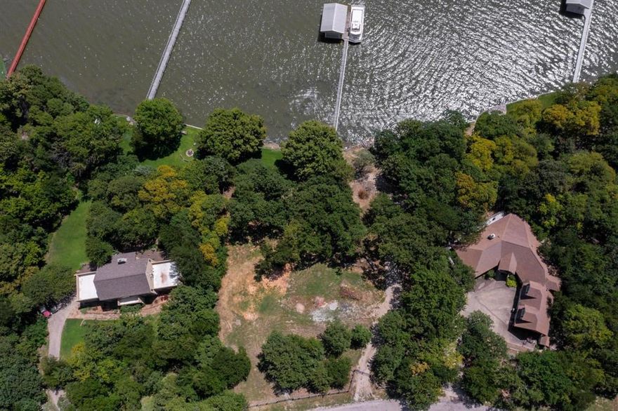 Build your dream home on this beautiful lakefront property at Eagle Mountain Lake. NO HOA. Mature trees, boat dock on lot 6, outside city limits, well on lot 6, co-op water available, minimum 1600 sq foot building restriction. Depth of water is approx 5-7 feet when full depending on the level of the lake. Beautiful custom homes on each side of the lots. Lot 5 is approx .531 and lot 6 is .45. Cul-de-sac, gray wood fence with two gates. Will sell lot 5 & 6 separate.