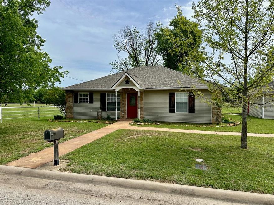 Charming 3 bedroom, 2.5 bath home situated on approximately 1.99 acres within the city limits of Brownwood, Texas. Located on a quiet street near the center of town, this property offers space, convenience, and a peaceful setting.

The home features hardwood flooring in the living room, kitchen, bathrooms, and hallway, with carpet in all three bedrooms. The interior has been recently painted, professionally cleaned, and carpets have been freshly cleaned, making it move-in ready.

The living room is located at the back of the home and features a wood burning stove along with large windows that provide a beautiful view of the backyard and acreage. The kitchen offers nice cabinetry along with an electric glass top range and dishwasher. Ceiling fans are located in the living room, kitchen and dining area, and two of the three bedrooms.

The primary bedroom includes a private full bathroom with a sliding barn door. Two additional bedrooms share a Jack and Jill style full bathroom, and a convenient half bath is located in the hallway for guests.

Additional features include central heat and air, washer and dryer hookups, and a two car detached garage with a workbench. An in ground storm shelter provides added safety.

The exterior offers plenty of space with pipe fencing along the acreage boundary, several shade trees, a three sided shelter suitable for animals such as horses, and an open deck on the back of the home. A backyard fire pit provides a great space for relaxing outdoors.

The acreage and fencing also provide a great setup for FFA and 4-H projects, with room for livestock such as goats, sheep, or calves.

Located near Brownwood High School and within the East Elementary school district, this property combines the benefits of acreage living with the convenience of being in town.