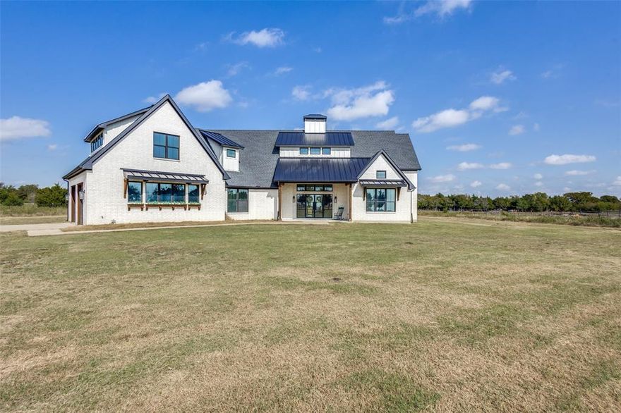 Beautifully maintained home nestled on 3.8 fully fenced acres surrounded by mature pine trees and stunning sunset views. This 1.5-story home features 4 bedrooms and 3 full bathrooms, all on the main floor, with engineered hardwood flooring throughout.

The spacious, open-concept kitchen is a chef’s dream with GE Café gas stove and oven, quartz countertops, a farmhouse sink, and a double-sided fireplace shared between the kitchen and living room- perfect for cozy gatherings and entertaining. The home features stunning vaulted ceilings with rich wooden beams in the entryway, kitchen, and living room, creating a spacious atmosphere. The primary suite offers serene acreage views, a shiplap ceiling, and a spa-inspired en suite bath with a luxury soaking tub, and his-and-hers walk-in closets.

Upstairs includes a large game room and loft area — perfect for entertaining or a flexible living space.

The fully fenced acreage also features a 25’ x 50’ workshop with a 16-ft peak ceiling and three 10-ft shutter doors, ideal for projects, storage, or equipment.