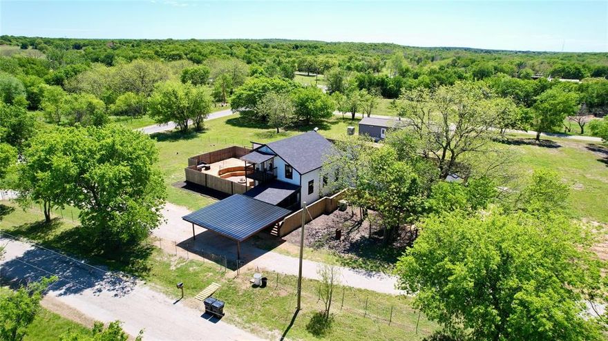 Welcome to your country retreat in the heart of Oran, TX! Built in 2023 and situated on just over 0.8 acres, this spacious 2,672 sq ft two-story home offers the perfect blend of modern comfort and small-town charm within Graford ISD. Step inside to an open-concept living area featuring soaring vaulted ceilings, warm wood accents, Luxury Vinyl Plank flooring, and abundant natural light. Beautifully updated kitchen, complete with white cabinetry, ample counter space, and a functional island—ideal for gathering with family and friends.
Featuring 3 bedrooms and 2 bathrooms downstairs and an office, one bedroom upstairs, this home offers flexible space for growing families or lots of guests. The upstairs retreat includes a private balcony—perfect for enjoying peaceful country views and Texas sunsets.
Outdoors is where this property truly shines. The custom-built entertaining area features a sunken fire pit, outdoor kitchen space, and expansive wood decking—all enclosed for privacy and designed for hosting unforgettable evenings. Whether you're grilling, relaxing by the fire, or enjoying wide-open skies, this space delivers. Additional highlights include—new 2-car carport, new water well; fully fenced yard, covered front porch wired for tv; plenty of room for parking or future improvements, and new septic. Located in the quiet community of Oran, just minutes from Graford and Possum Kingdom Lake, this property offers the best of rural living with convenient access to recreation and amenities. If you're looking for space, style, and a place to truly enjoy the outdoors—this one is worth a look!