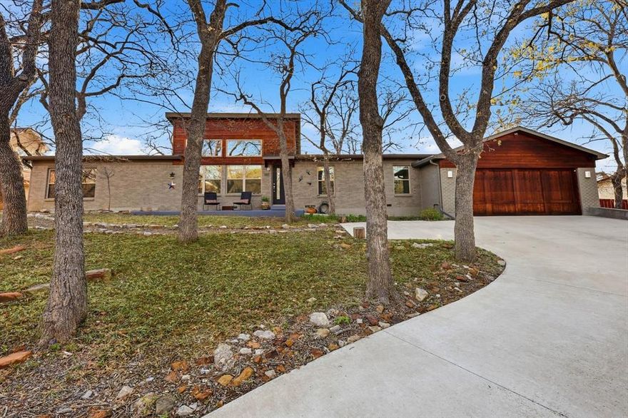 This unique, architect-owned designed, and completely remodeled home (in 2017) is located on a secluded and quiet cul-de-sac in Highland Village. It is a 5-minute walk from Lewisville Lake, surrounded by Post Oak trees, and features 4 bedrooms and 2 full bathrooms. The oversized primary bedroom includes a large walk-in closet, a spacious bathroom, and views of the front yard. The beautiful kitchen boasts an oversized quartz island and a spacious walk-in pantry. The modern, high-ceiling living room features a built-in electric fireplace. Hickory wood floors run throughout the home, and there is a large, tiled laundrymud room with built-in shelving. The home also includes a completely screened-in back patio and a third acre yard with over 25 large mature trees that provide plenty of shade. The oversized garage includes additional rear storage space and shelving, Spray foam insulation throughout the home helps reduce utility costs. There is no HOA. Multiple nearby parks, hiking trails, boating and fishing areas are easily accessible. Cameras, TV antenna & reverse osmosis filter will convey. Furniture negotiable inside and out.