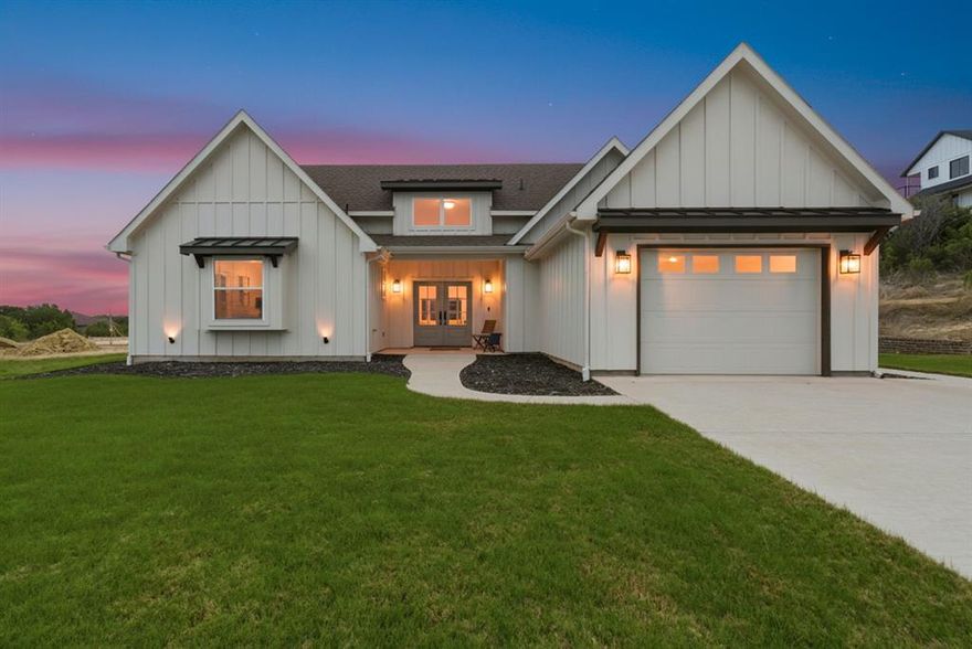 Discover effortless elegance in this feels like-new 2 bedroom, 2 bath home where thoughtful upgrades and timeless style come together beautifully. From the moment you step inside, the home’s cathedral ceiling creates a sense of openness and grandeur, complementing the light-filled open-concept living and dining area designed for both everyday comfort and entertaining.  The kitchen serves as the heart of the home, featuring granite countertops, an upgraded window above the sink that fills the space with natural light, and a refrigerator that remains with the home for true move-in ease. The inviting living area is enhanced by an electric fireplace adding warmth and ambiance to the space.  Luxury continues in the private primary retreat with upgraded bath finishes, elegant wall tile, creating a spa-inspired atmosphere.  Two additional versatile rooms provide the perfect setting for a home office, studio, or hobby space, offering flexibility for today’s modern lifestyle.  Exceptional upgrades set this home apart, including extensive electrical enhancements, designer lighting, a water softener system with reverse osmosis in the kitchen, and a full sprinkler system for easy maintenance.  Outside, charming front and west-side flower beds, a retaining wall, and an oversized one-car garage enhance both functionality and curb appeal. The backyard presents an open canvas, inviting you to create the outdoor retreat of your dreams—whether a garden sanctuary, entertaining pavilion, or peaceful relaxation space on the back porch with your favorite beverage.  Impeccably maintained and beautifully appointed, this home offers a rare blend of style, comfort, and opportunity.  Welcome to Mountain Lakes, Bluff Dale Texas where the amenities are icing on the cake. 2 private lakes, exercise & play parks, RV parking & storage, clubhouse, community garden and pool.