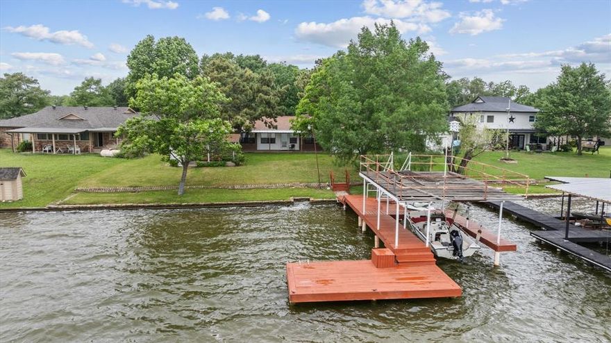 Hard to find Main Body Lake living on Lake Granbury.   This home is a 3 bedroom, 2 bath with oversized Living room and foyer that was added and could be a bunk room, game room area or space for the grandkids to add beds to come see the grandparents to enjoy the Lake.  The home has a 48 foot covered back porch that opens up to the backyard and  rock wall along the lake for easy access.  The boat dock is covered with a boat sling, area to fish off or swim off.  Home has a beautiful front yard with trees and 2 car garage,  the home could be renovated for added space with garage or added area in living room or foyer if you need more sleeping space.  This home is ideal for a family who wants to play, ski, boat or vacation in Historic Granbury.  The home has a covered area off the storage shop in the backyard for added picnicing or sitting and just watching the water.  You will fall in love with the backyard and evening entertaining.  Fish, ski, swim, boat or just relax.  Home is on AMUD water, has a sprinkler system, gutters around the home,  wood burning fireplace in the family room.  So many memories to be made and just waiting for you to come start enjoying Lake Granbury,  buy it now and be in by the Big Fourth of July Lake Granbury celebration.