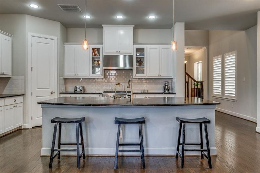 Located in the desirable gated community of Villas of Lake Highlands, this beautiful home blends timeless design with thoughtful updates, creating a warm, inviting space ideal for everyday living and entertaining. Rich hardwood floors run throughout the entire home, complemented by plantation shutters and designer lighting in an open concept layout where the spacious living room flows seamlessly into the gourmet kitchen. Crisp white cabinetry pairs with black soapstone countertops, a subway tile backsplash, and stainless steel appliances, while the large center island provides breakfast bar seating for casual meals and conversation. The adjacent dining area overlooks the backyard and enjoys open sky and tree views, as there are no two story homes behind the property, creating a more private and peaceful setting. The luxurious primary suite offers a private retreat with vaulted ceilings, a sitting area, and elevated views that make the bedroom feel like living in a tree house, surrounded by beautiful mature trees. The spa inspired bath features a soaking tub, glass enclosed shower, dual vanities, and modern tile finishes. Additional bedrooms are generously sized and complemented by a beautifully appointed bathroom, while a versatile upstairs nook offers flexible space for a home office, reading area, or additional living space. Step outside to a covered patio ideal for morning coffee or evening gatherings, complete with a fenced yard that is low maintenance yet spacious enough for pets or play. The backyard benefits from the absence of two story homes behind it, enhancing privacy and preserving the open feel. A dedicated laundry room, guest powder bath, and ample storage add convenience. Residents enjoy access to a sparkling community pool, lush park, and green space within the gated neighborhood. With shopping, dining, and major commuter routes minutes away, this home offers comfort, style, and an exceptional Lake Highlands location.