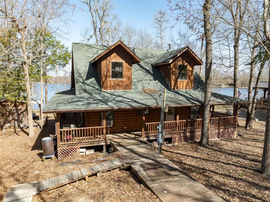 WATERFRONT LOG HOME DREAM PROJECT ON CALLENDER LAKE:  Bring your vision to this partially finished rustic log home in the gated community of Hickory Hills.  This community is located on the beautiful 365 acre spring fed Callender Lake near Murchison, Texas.  Featuring a 2 bedroom, 2 bath layout with a charming upstairs loft, this property is a perfect blank canvas to have your dream lake getaway.  The exterior features authentic log home charm with a walk around covered porch with great views of your water front property.  The interior has a partially finished bedroom, bathroom, and kitchen and the rest of the home is waiting for your finishing touches.  Imagine sipping coffee in  your high-ceilinged loft, enjoying views of the tranquil surroundings.  The structure is sound, offering the classic log-cabin experience.  The home is insulated and totally wired.   Home has working electric and septic systems.  The community has a water system but it is not currently used by the home.  The home currently has a rain catchment system that is used by the current owners.  Yard has a chain link fence on all four sides.  The retaining wall and boat dock need work.  The boat also comes with the property.  With a little TLC and work this home will be one to keep in your family for years to come.   The community of Hickory Hills has a community pool, fishing dock, restroom and shower facility, boat ramp, children's park, and great fishing and boating for you to enjoy.   Come see this home with tons of potential today.