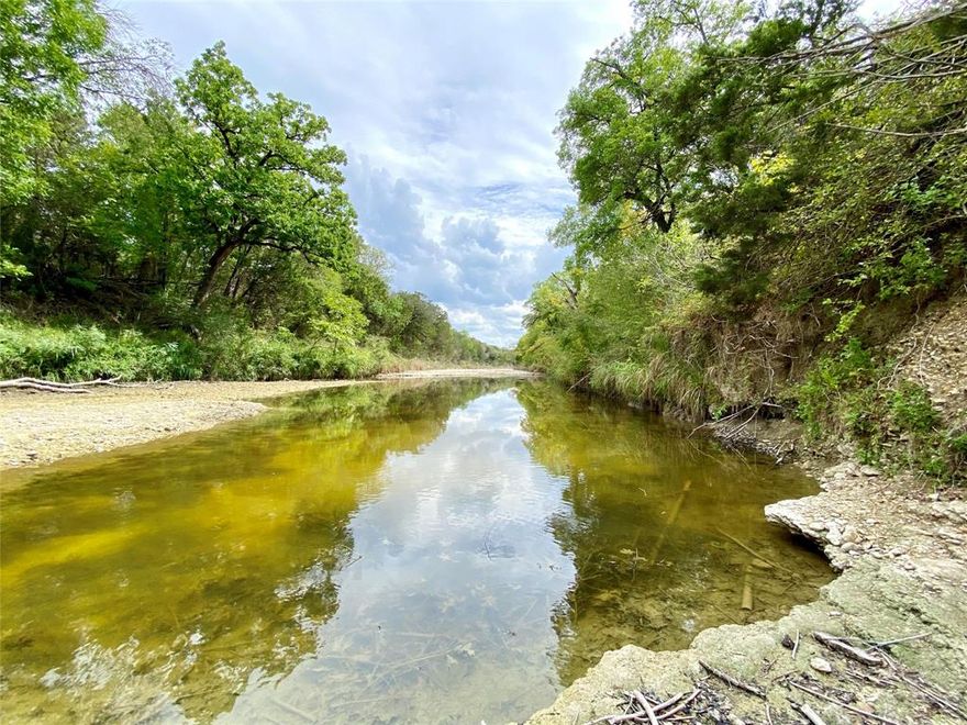 Creekview Ranch is a hidden jewel in Bosque County! The 169-acre ranch is diverse with approx. 85 pasture acres, a 20-acre coastal plot, hardwoods throughout, approx. 5000' of frontage on Neil's Creek, rolling hills, and elevation changes of 60'. The 1970 home has 2,414 sqft with a spacious, open-concept kitchen & den combo. Large windows throughout the home and across backside of the home. Views of the nestling oaks and countryside off the back deck where deer frequently traverse. A stone fireplace and vaulted ceilings in the family room are accented with wood beams. 2 BR 2 BA. Game room has a bar and pool table. Guest house built in 1945 has firesplace and den area, kitchen and nook, 4 BR 2 BA with 1,492 sqft. Trinity well in need of repair.  Rural water meter.  50’x30’ metal shop with concrete floors and two 14’ roll-up doors.  Dutch-style barn for additional storage and a building shed with concrete floors. Pen and chutes behind barn. Clifton ISD.