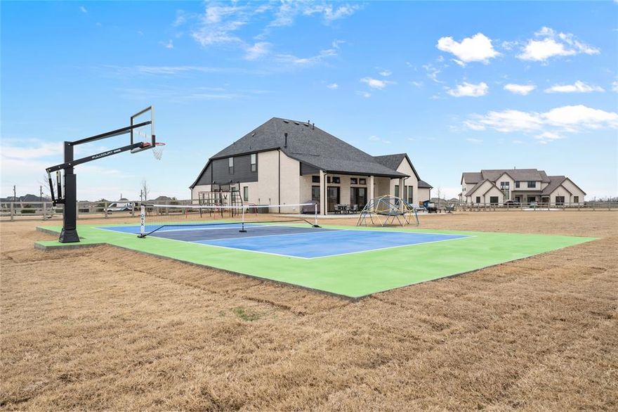 BETTER THAN NEW!! 2024 masterpiece with all of the new construction kinks worked out. Nestled in the sought-after, master-planned community of Harvest directly across from the serene community fishing pond. Featuring 5 spacious bedrooms, each with its own ensuite bathroom, plus a convenient half bath for guests; this home is ideal for luxurious living and effortless entertaining. Enjoy the elegance of a HUGE chef’s kitchen outfitted with a gas cooktop, double ovens, walk-in pantry, and abundant cabinetry. The open-concept floorplan flows seamlessly into a large back patio, highlighted by a stunning sliding glass wall and pre-wired for outdoor speakers—perfect for gatherings. This smart home, powered by HomePro Smart Home Services, also includes a private office, a media room pre-wired for surround sound, and a massive utility room with cabinetry and a sink. The primary suite offers a spa-like retreat with a garden tub, a walk-through shower, and a customizable closet system. Additional features include: Second bedroom with ensuite on the main level – ideal for multi-generational living or guests, Tesla charging station and epoxy flooring in the oversized 4-car garage, Circle driveway for added curb appeal and convenience, HUGE extended patio, Custom sport-court for basketball and pickleball, Full sprinkler system, fenced 1.69 acre lot with strategically placed French drains, Room-darkening blinds, City water and sewer. Ideally situated in award-winning Argyle ISD and offering an incredibly low tax rate. This home offers the perfect blend of elegance, functionality, and location—don’t miss your chance to own a slice of luxury in Harvest!