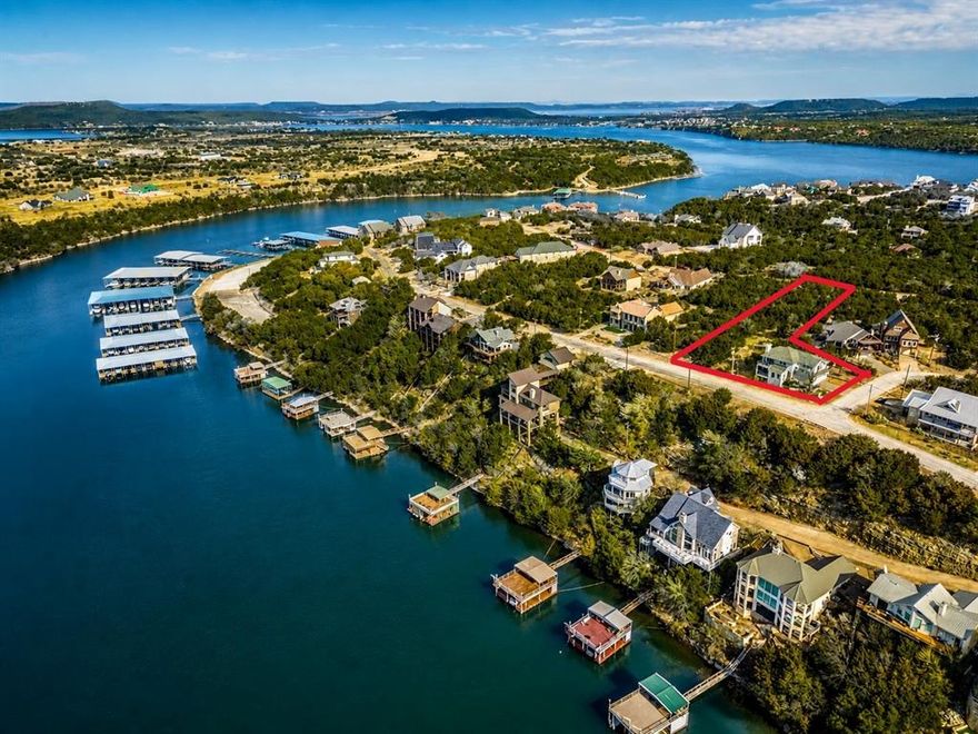 Exceptional two lot estate property with transferable boat slip, a truly rare find. Experience refined lake country living in this exquisitely updated residence located within the prestigious, gated Cliffs Resort on Possum Kingdom Lake. Offering stunning lake views and a hidden vantage point for the iconic Hells Gate 4th of July fireworks, this beautifully fully furnished home showcases an exceptional blend of luxury, comfort, and resort-style amenities, making it a rare turnkey opportunity ready to enjoy from day one. The thoughtfully designed floor plan features three bedrooms, two and a half bathrooms, and two spacious living areas. A large eat-in kitchen anchors the home, offering ample countertop space and an inviting layout perfect for gatherings, while expansive windows capture breathtaking lake vistas throughout the living spaces. Recent enhancements include fresh exterior and interior paint, rich hardwood flooring creating a seamless, upscale aesthetic throughout. The primary suite is a true retreat, highlighted by a completely remodeled, spa-inspired primary bathroom designed for relaxation and sophistication. Elegant statement chandeliers elevate both the front entry and dining room, adding architectural interest and a strong sense of arrival. Outdoor living is equally impressive. Fresh landscaping surrounds the home with curated bushes, exotic plants, and stone accents. A rare second lot expands the lifestyle possibilities, featuring a private spa-hot tub and a thoughtfully designed fire pit area with additional landscaping—perfect for entertaining or enjoying tranquil evenings under the Texas sky. For those seeking future expansion, the property includes two complete sets of architectural plans for a potential home addition, complete with multiple renderings showcasing pool and backyard concepts—an exceptional opportunity to further customize an already impressive residence.