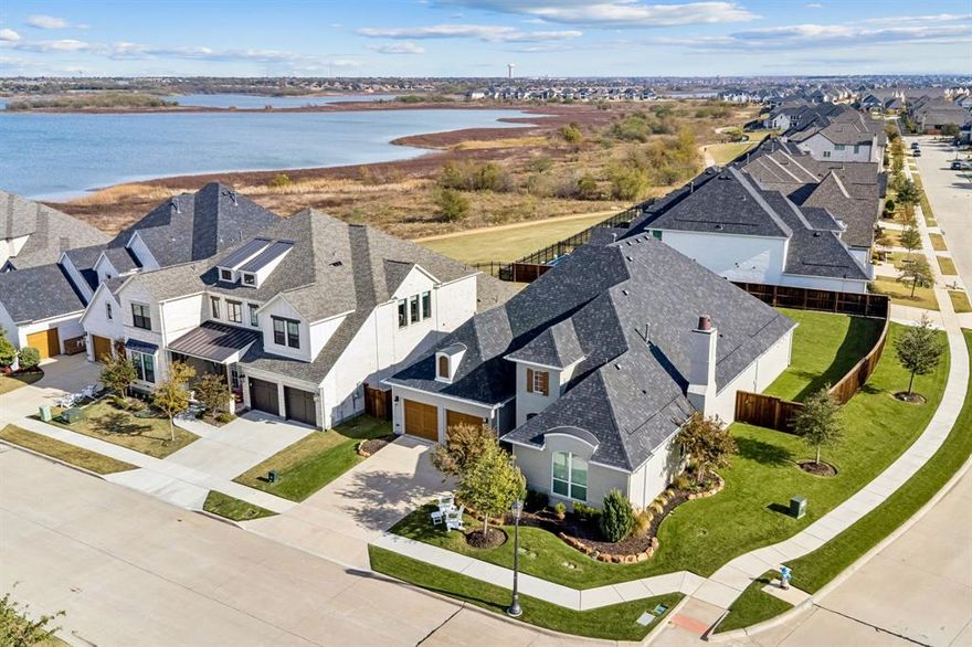 Experience unparalleled luxury and breathtaking water views at 2816 Maryport Ct. in The Tribute Golf & Resort Community! This stunning one-story home offers over 3,000 sqft of luxury living, and is ideally positioned on a quiet cul-de-sac with captivating front-facing lake views. Charming painted brick and lush landscaping welcomes you inside to a bright, airy entry with trey ceilings, wide-plank engineered hardwood floors, plantation shutters, custom blinds, designer chandeliers, and thoughtfully selected paint, fixtures, and finishes creating a refined, cohesive ambiance throughout. The gourmet kitchen is a chef’s dream, featuring floor-to-ceiling custom cabinetry with lighted glass-front uppers, an oversized custom quartz island, gas range, and a large walk-in pantry. The living area was made for entertaining, highlighted by a dramatic floor-to-ceiling stone-accented fireplace, soaring 20-foot ceilings with a wood beam, and a custom 3-panel slider door that opens to a private covered patio retreat with picturesque views of the almost .3  acre lot. The backyard is an entertainer’s paradise with endless opportunities for outdoor living and al fresco dining. The thoughtful split-bedroom layout ensures privacy, with 3 spacious bedrooms each with spa like ensuite baths and large walk-in closets, while a private office & a dedicated media room add to the homes functionality. The extended 3-car garage, each expanded by an additional 3 feet, offers Diamond floor coating, custom overhead storage racks, and a rare convenience: an elevator providing effortless access between the garage and attic. This home delivers an unmatched lifestyle located within walking distance to the new marina, the Lakeside Pool with stunning lake views, pickleball courts, children’s splash pad, playgrounds, dog parks, kayak launch, two award-winning golf courses, and over 13 miles of scenic hike and bike trails. This lakefront luxury home is an absolute MUST SEE!