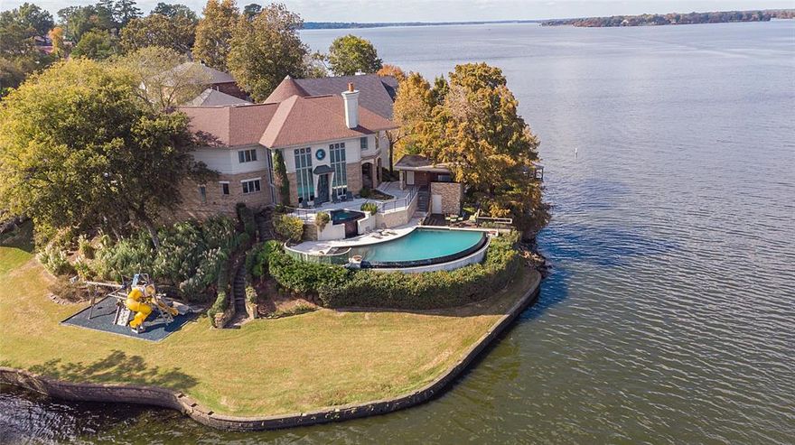 **Exquisite Global Luxury Estate on Cross Lake**

Experience the pinnacle of sophistication and comfort with this stunning Global Luxury estate nestled on a great lake lot in Shreveport. Featuring 3 expansive bedrooms and 3.5 elegantly appointed baths, this residence boasts a harmonious blend of classic charm and modern amenities. With a meticulously designed layout and a 2 car garage, this home provides both convenience and luxurious living.

**Interior Elegance:**
Step inside to discover an oasis of luxury with soaring ceilings, hardwood flooring, and expansive windows that flood the home with natural light and wonderful lake views from just about every room in the home. The living area is anchored by a refined fireplace, perfect for intimate gatherings or grand entertaining. The dining room offers a sophisticated space for hosting dinners, effortlessly flowing into the spacious living area. The wet bar is just off the living room with an ice maker, wine cooler and a refrigerator.

The primary suite is a private retreat, offering a serene view, walk-in closet, and a sumptuous en-suite bathroom that includes a soaking tub, separate large walk-in shower, and dual vanities. Each additional bedroom is a sanctuary in its own right, featuring ample closet space and private bathroom access, ensuring comfort and privacy for all residents.

**Exterior Tranquility:**
Outside, the landscaped grounds provide a peaceful retreat with meticulously maintained gardens and a spacious patio perfect for alfresco dining. The backyard is an entertainer’s dream, offering idyllic spots for lounging and relaxing in the tranquility of your own private paradise. Their is an infinity hot tub and heated infinity pool overlooking the lake.

This Global Luxury property is not only a home but a complete lifestyle package, offering unmatched style, comfort, and function. Experience the best of Lake living! This property is sold as is. The tree by the outdoor kitchen is being removed.