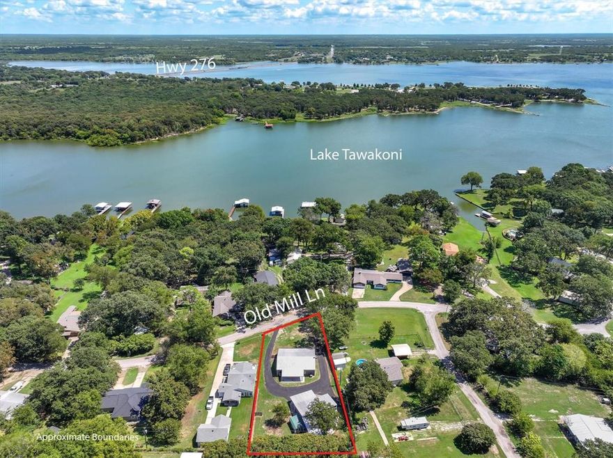 Lake Tawakoni views from this completely 2025 remodeled home with a shop in a well-kept neighborhood of Whispering Oaks! Austin stone front, easy to maintain metal exterior, metal roof on a large .40 acre lot.  Sit on the gorgeous, landscaped and raised 500 SF covered front porch and enjoy the views of the lake! Open concept home with private master suite on one side of the home with entry to porch. Primary suite is large with large walk-in closet, ensuite bath with soaker tub, dual sinks and separate tiled shower. Kitchen has been beautifully updated and remodeled with butcher block counters, custom cabinets and 2025 SS appliances. Large utility room has room for other appliances. Guest bedrooms share a remodeled guest bath with tiled tub shower. Guest bedroom #2 has its own entry onto the porch. There is plenty of covered parking, new asphalt circle driveway makes a horseshoe around the back of the home and in front of the 50x30 shop with upstairs loft! Park you truck and boat in the boat area of the shop.  Additional covered concrete parking behind the shop for more equipment and toys! Greenhouse. Rains ISD!  Community boat ramp and no HOA! Lake life awaits!