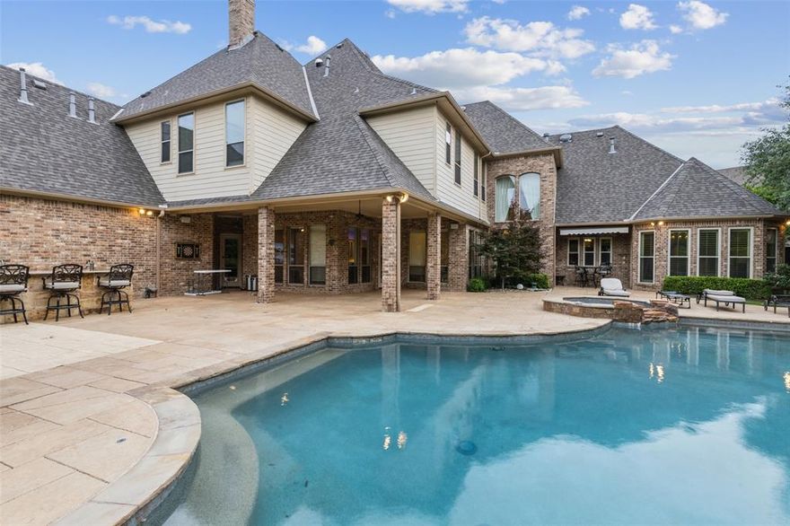 Discover refined living in this exceptional estate, nestled on a quiet cul-de-sac in the prestigious Timarron – Eagle Bend Estates. Perfectly positioned within award-winning Carroll ISD, this Southlake residence combines timeless elegance, modern convenience, and an unbeatable location. Set on a half-acre lot, the home spans 6,729 square feet with 7 bedrooms, 7 full baths, and 3 half baths—designed to accommodate both intimate living and grand entertaining. The dramatic two-story foyer with sweeping staircase sets a stunning first impression, flowing seamlessly into light-filled living and dining spaces with rich architectural details. The chef’s kitchen is a true centerpiece, showcasing quartzite countertops, a spacious island, induction cooktop, commercial vent, built-in refrigerator, butler’s pantry, and walk-in pantry—perfectly suited for gatherings large or small. The primary suite offers a private sanctuary with its own sitting area, spa-inspired bath, oversized walk-in shower, soaking tub, and custom closets. Six additional ensuite bedrooms provide comfort and privacy for family and guests alike. Additional highlights include a dedicated media room, private office, dual staircases, plantation shutters, hardwood flooring, surround sound wiring, decorative lighting, and smart home features. Step outdoors to your backyard retreat, complete with a covered patio, outdoor kitchen, sparkling pool, spa, and a large grassy area ideal for play or pets. The oversized 3-car garage provides abundant storage plus a dedicated gym space. Beyond your doorstep, enjoy Timarron’s resort-style amenities—clubhouse, tennis courts, community pool, trails, parks, and a scenic lake. Just minutes from Southlake Town Square, golf, and dining, this residence offers a lifestyle of convenience and luxury.  Schedule your home tour today!