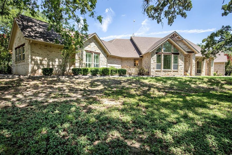 Stunning custom home on 9.16 acres in an exclusive gated community with access to both a private airpark and the Brazos River. This beautifully crafted residence features natural Hickory floors, vaulted wood-beam ceilings, and an open-concept design bathed in natural light. Each bedroom offers direct access to the resort-style patio and sparkling pool. The romantic primary suite includes a gas-log fireplace, luxurious glass shower, dual vanities, a spacious walk-in closet, and a private sunroom—ideal for a gym, office, or sitting area. The hall bath offers a spa-like retreat with a freestanding soaking tub, elegant tile flooring, and a walk-in shower with dual rainfall heads and river rock accents. Entertain with ease on the covered patio or in the expansive cabana with full bath, which connects to a versatile space perfect for a workshop, gym, or studio. Enjoy serene views, daily wildlife, and unmatched privacy in this rare blend of luxury living, aviation convenience (Airport Identifier XA86), and riverfront lifestyle.