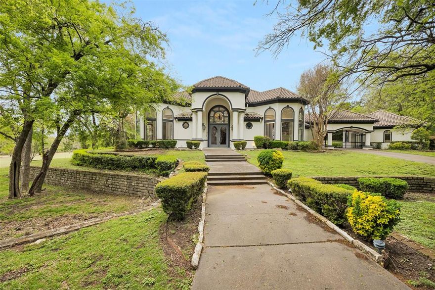 Step into a world of elegance and comfort in this 10,980 sq. ft. estate, nestled in the prestigious gated Thorntree golf-course community. Designed for those who love to entertain and unwind, this 5-bedroom, 6.5-bathroom mansion offers a seamless blend of sophistication and resort-style living.
From the moment you walk through the grand entryway, vaulted tray ceilings, intricate crown molding, and rich wood and tile flooring set the stage for a home that exudes both charm and grandeur. The gourmet kitchen—outfitted with Viking appliances, granite countertops, an oversized island, and an expansive pantry—is a chef’s dream and the heart of the home. For book lovers, a beautiful private library offers the perfect retreat, while the dedicated home office ensures a productive workspace with privacy and elegance. And when it’s time to relax, head to the spa room, thoughtfully designed to accommodate massage beds and ultimate relaxation—your personal wellness sanctuary at home. The primary suite is nothing short of a retreat, featuring a custom walk-in closet with built-in shelving and a storage island. Cozy up by the double-sided fireplace, which seamlessly connects the suite to the spa-like master bath, complete with dual vanities, a jacuzzi tub, and a separate shower. Upstairs, a grand iron staircase leads to a spacious media room, game room, and additional bedrooms, ensuring that there’s room for relaxation and recreation. And the outdoor space? A true oasis—a sparkling pool, an indoor spa, and a private pond create the perfect setting for unforgettable gatherings. With a five-car garage, this home effortlessly combines functionality with luxury. Just 12 minutes from Dallas Executive Airport, 20 minutes from downtown Dallas, and a short drive to top shopping destinations, and 14 minutes from Joe Pool Marina. This estate offers the best of privacy, luxury, and convenience. Your dream lifestyle starts here—schedule a tour today!