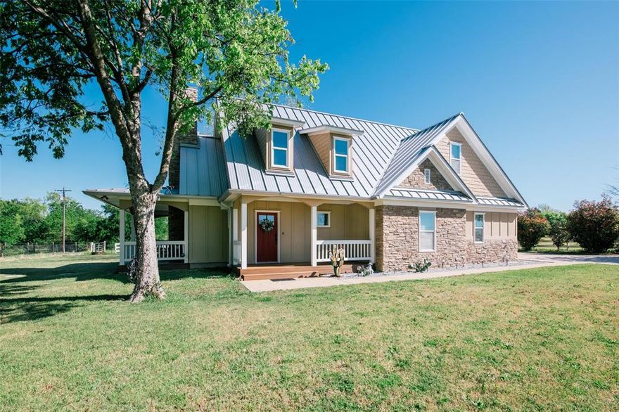 Nestled beneath mature trees and framed by sweeping views, this charming 2015 home at 9373 FM 428 offers 1,976 sq ft of warmth and character on 6.65 acres. A welcoming wrap-around porch and a private screened porch off the primary suite invite you to slow down and take it all in. Inside, a floor-to-ceiling stone fireplace anchors the living room, while rich hardwood floors and a spacious kitchen with white cabinetry, subway tile, granite counters, double ovens, gas cooktop, and farm sink make this home as beautiful as it is inviting. The main level primary suite features an ensuite bath, with two additional bedrooms upstairs. A one-car attached garage, detached two-car garage with extra storage, and well-fed sprinkler system round out this truly special property. This property could be used as a primary residence, but is being sold as a guest house to the neighboring property. Sold in conjunction with 9325 FM 428, MLS #21235502. Come experience this exceptional property.