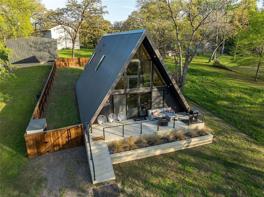 Elevated open water views pair with lake access at this A-frame retreat in a Cedar Creek Lake community with a neighborhood boat ramp and dock providing convenient access for fishing, boating, and enjoying the water. Currently operating as a successful short-term rental, this property offers an excellent opportunity as a weekend getaway or income-producing investment.

The 1725 square foot, 3 bedroom, 2 bath layout is thoughtfully designed to maximize space and functionality, with two bedrooms and a full bath downstairs, ideal for guests. The open living area features soaring ceilings with modern wood detailing and flows into a well-appointed kitchen and built-in bar space perfect for gathering and entertaining. The main level offers low-maintenance sealed concrete floors and thoughtfully integrated storage throughout.

Upstairs, a loft area at the top of the stairs provides a flexible space for a workspace, reading nook, or games area. The private primary suite is separated by a door for privacy and includes its own full bath, hardwood floors, and full-size closet.

Luxury finishes are carried throughout, including waterfall countertops, upgraded fixtures, and modern walk-in showers in both bathrooms.

Exterior features include a board-on-board cedar privacy fence creating a great yard space for pets or play, and gravel driveway.

Located just over an hour from Dallas and near local favorites including Fig’s Backyard, Fig’s Steakhouse, Whatz-Up Fun Park, Cedar Creek Brewery, Triple N Winery, and boat rentals at Lone Star Marina, this property delivers the ideal Cedar Creek Lake escape with built-in investment potential. Furniture package available separately.