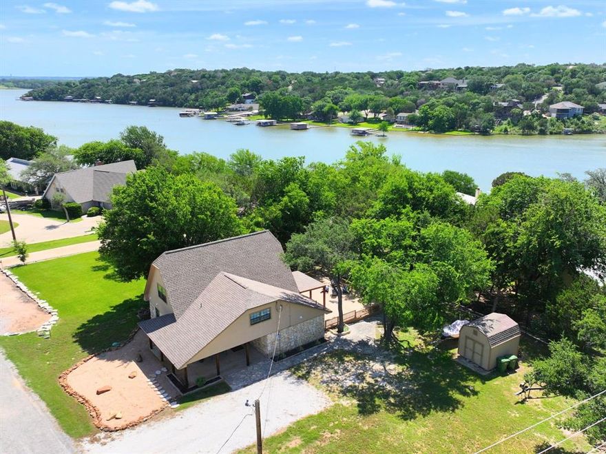 Rare waterfront opportunity on natural inlet of Lake Granbury. This beautifully updated home sits on a corner lot surrounded by mature trees and includes its own private BRAND NEW boat dock—making lake life effortless and accessible right from your backyard.

Inside, the home offers a practical and inviting layout with open living spaces, abundant natural light, and modern updates throughout. The island kitchen features stainless steel appliances, ample cabinetry, and stunning quartz countertops—perfect for entertaining or everyday living. The oversized bedrooms provide plenty of space, with the primary suite conveniently located on the first floor for added privacy. A full-size laundry room connected to the primary bath enhances daily functionality with generous storage options. Upstairs, you’ll find two additional bedrooms, a full bath, and a large bonus room ideal for a game room, office, or flexible guest space. This home has tons of walk-in storage and closet space like you've never seen before! There's room for EVERYTHING!

The outdoor living is where this property truly shines. A spacious deck overlooks peaceful water views and offers the perfect setting for hosting, relaxing, or enjoying quiet mornings with coffee by the lake. With quick access to boating, fishing, and lakeside lounging, this backyard is designed for year-round enjoyment. Property has a storage building perfect for lawn or lake toys.

Located in a gated community, this home provides added security and peace of mind—ideal for full-time living, a weekend retreat, or a short-term rental investment. Home is just seconds from the neighborhood marina. Conveniently close to shopping, dining, and everyday essentials while still offering a private, relaxed atmosphere.

With an acceptable offer the furniture and decor convey making this home truly turnkey for the summer! Waterfront homes like this are hard to find. Don’t miss the chance to experience true lakeside living.