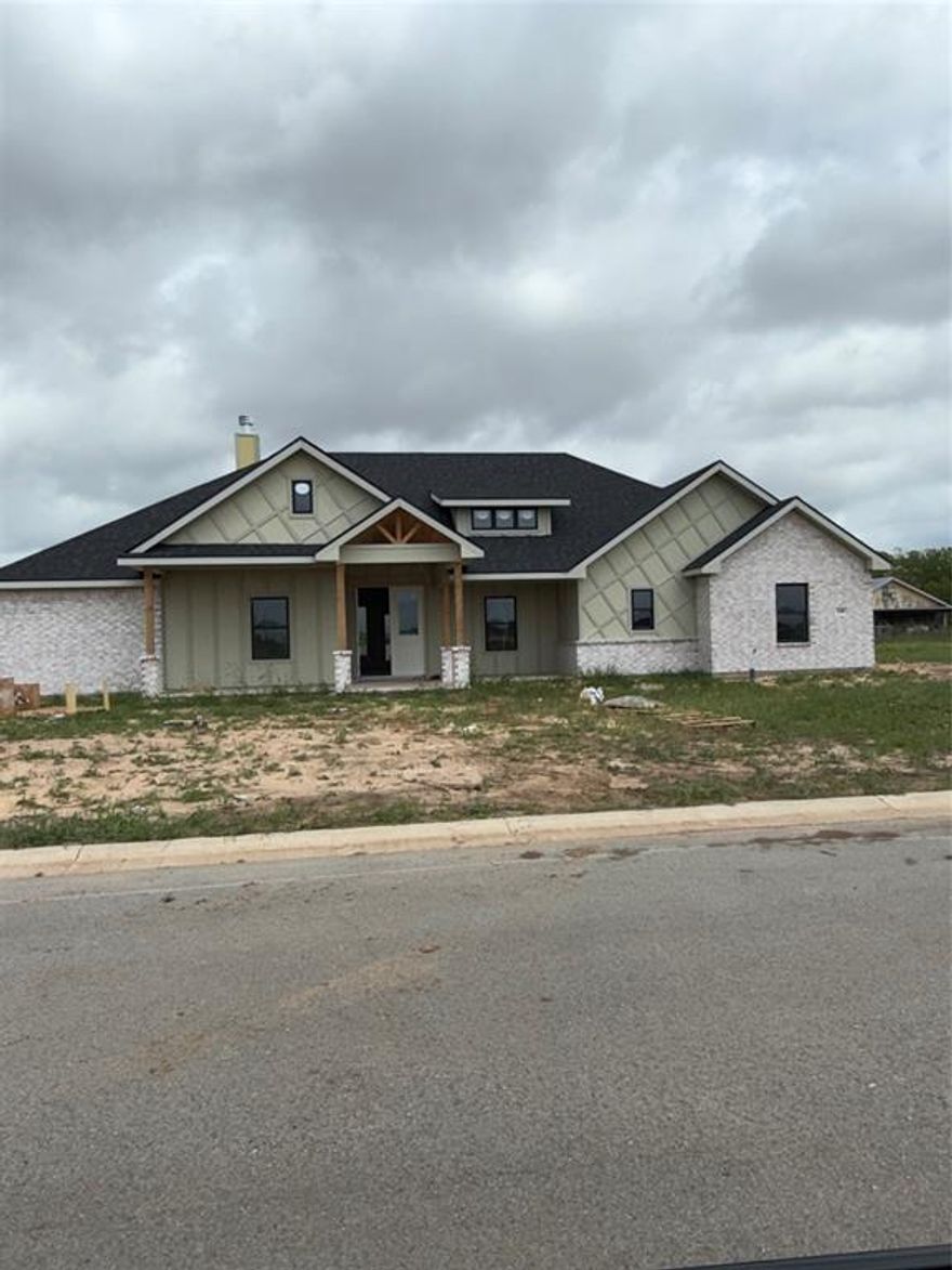 Welcome to this charming 4-bedroom, 3-bath home nestled on a spacious corner lot in the sought-after Wild Horse Trails subdivision within Jim Ned ISD. Designed with warm Southern appeal and thoughtful functionality, this home offers an inviting layout perfect for both everyday living and entertaining. Step inside to find luxury vinyl plank flooring flowing throughout the main areas and a cozy wood-burning fireplace with a gas starter anchoring the living room. The open kitchen is sure to impress with quartz countertops, a large island, stainless steel appliances, gas range, walk-in pantry, and plenty of workspace for home cooks to enjoy. The primary suite provides a relaxing retreat featuring a soaking tub, tiled shower, dual sinks, and a spacious walk-in closet. A separate guest wing includes a convenient Jack-and-Jill bathroom for two bedrooms plus an additional third full bath ideal for guests or a growing family. Outside, you’ll appreciate the backyard fencing, full irrigation system, and lush sod in both the front and back yards, offering move-in ready curb appeal. This Southern-inspired home blends comfort, style, and modern amenities—don’t miss your chance to make it yours!