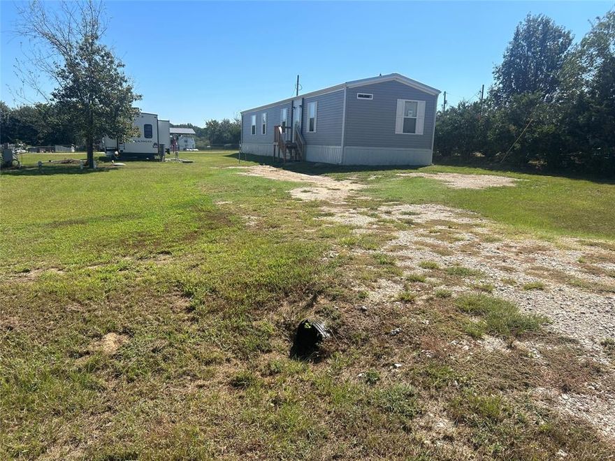 Wow, beautiful New home. This home is a 3 bedroom 2 bath manufactured home located in a gated community on Lake Fork. House sits on two lots, the layout of the house is spacious and open and the windows offer plenty of natural light during the day.  The master bedroom not only provides a walk-in shower, but also has a standalone tub and double sinks to give you plenty of personal space when getting ready to head out for the day. The property has a spacious yard great for gathering with family and friends and is located only a block away from the clubhouse and swimming pool. Holiday Village allows RVs, site built homes, as well as mobile homes that are under five years old. Building pimp permits And a mandatory HOA fee of $52 per month are required. Water and sewer bills are approximate $65 a piece each month. Benefits of living in the community include a clubhouse, swimming pool, basketball court, playgrounds, fishing ponds, boat ramp and a fishing pier.