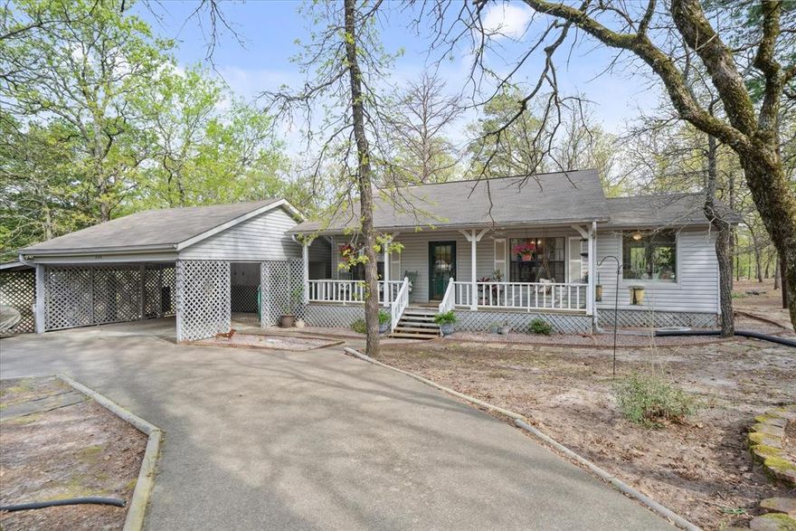 Beautifully maintained home in gated community. The cute covered front porch with a swing makes the most sublime entrance into the home. The open concept between the living room, kitchen and sunroom,which is currently being used as a formal dining room, makes this home feel spacious, light and bright from all the sunlight streaming in from multiple large windows. The master bedroom, with its own bathroom, is generous in size and has its own private sunroom office area overlooking the wooded peaceful backyard. The 2nd bedroom is also a nice size which can accommodate several nice sized pieces of furniture. The laundry room can be accessed from both bedrooms which makes tending to laundry so much easier. This house sits on over a half acre and has a fenced back yard for your pups. There's a dog door from the office sunroom. The backyard also features a nice deck area. There is a shed which could be used for storage or made into a small workshop or she shed. 2 car covered parking with lots of storage and even a place for the golf cart! You will love the paved circle driveway and beautifully maintained yard. The lots that this home sits on has many trees and great areas for feeding the birds, attracting deer and other wildlife. Come take a look at this charming comfortable home that has a nicely laid out floor plan which makes the home feel really spacious.  It would make a perfect vacation home or your permanent home nest.