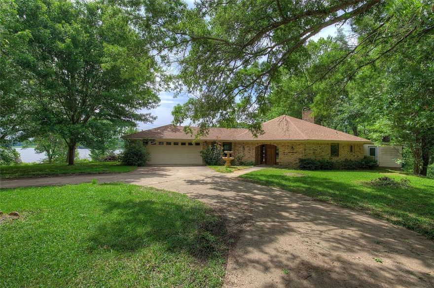 Discover a rare opportunity to own a 6.10-acre waterfront estate on the pristine shores of Lake Cypress Springs. This solid brick home offers over 678 feet of expansive water frontage, providing breathtaking lake views from every main living area. The heart of the home is an open-concept living room featuring soaring vaulted ceilings, rich natural woodwork, and a cozy fireplace. The adjacent kitchen has been thoughtfully updated with classic wood cabinetry and granite countertops, flowing seamlessly into a bright breakfast area and a dedicated space for a large dining table—perfect for hosting family gatherings. 
The private primary suite serves as a true retreat, complete with its own fireplace for chilly evenings and a unique, dedicated hot tub room just steps away. Two additional bedrooms and a second full bath provide ample space for guests. Functional versatility abounds with an attached two-car garage; half of this space currently serves as a craft room or home office but can easily be restored to full garage use if desired. Outdoor living is a highlight, featuring a peaceful screened-in porch and a sunroom to soak in the scenery year-round. 
Beyond the main residence, the property includes a detached two-car garage and workshop, along with a dedicated RV cover for your adventure vehicles. While the home requires some TLC—including fresh paint, new flooring, and repairs to the wood deck and dock—it presents a blank canvas to create your dream lakefront sanctuary. With no HOA restrictions and the potential to further enhance the views by clearing select property lines, this expansive lot offers unmatched privacy and endless potential on one of Texas's most beautiful lakes.

This property is leasehold and under the jurisdiction of the Franklin County Water District.   www.fcwd.com