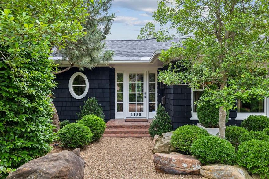 This Cape Cod-inspired Shingle Style home in Midway Hollow sits on a rare cul-de-sac, offering unmatched privacy on a half-acre estate lot. Lush landscaping with towering pines, Atlas cedars, and vibrant foliage creates a park-like setting. Pea gravel replaces traditional concrete for all driveways, paths, and open spaces. Inside, formal living and dining rooms connect to a high-end kitchen featuring a Sub-Zero refrigerator, Fisher Paykel drawer-style dishwasher, and GE Monogram dual-fuel range. Glass-front cabinets, soapstone countertops, and generous storage add to its charm. The dining room boasts Timorous Beasties wallpaper with silver leaf accents, complemented by relacquered woodwork and a grass cloth ceiling. The guest room is a fantasy retreat with Jakob Schaepfer wallpaper and luxurious layered textiles. Venetian plaster details enhance the appearance of the powder bath, master suite, and hallway, with ivory walls matched to the newly lacquered woodwork. The elegant living room, framed by French doors and terrace views, is lined with bookshelves and relacquered woodwork. The screened outdoor living space features vaulted ceilings, air conditioning, and a gas fireplace, while an adjacent cabana with a half bath provides easy pool access. The backyard is a sun lover’s paradise with a custom stone-lined 45-foot pool and spa, surrounded by lush greenery. A spacious garage with modern cabinetry accommodates three cars, completing this East Coast Hamptons-inspired haven—truly a one-of-a-kind Dallas gem!