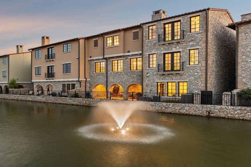 Welcome to 22 Comillas Dr, a meticulously cared-for waterfront townhouse with beautiful designer upgrades! Perfectly positioned along the canal in the heart of Westlake Entrada, a lock-and-leave community tailored for those who value refined living and everyday ease. Enjoy serene views of the canal, fountains, and stone bridge from multiple rooms of this home, along with curated finishes such as designer wallpaper, dimmable lighting, in ceiling speakers, and both under and over cabinet lighting. The light-filled kitchen offers canal views through the multiple windows and is well-appointed with Sub-Zero and Wolf appliances and custom cabinetry. A timeless cast stone fireplace, motorized custom made curtains, and a Juliet balcony overlooking the canal enhance the welcoming family room. The primary suite is a true sanctuary, featuring its own Juliet balcony with canal views, a built-in coffee bar, and a spa-like bath with dual vanities, a soaking tub, walk-in shower, expansive walk-in closet, and a private elevator for added ease and privacy. The floor plan offers two additional en-suite bedrooms, a spacious laundry room, and a private front-facing office—perfect for quiet focus and complete with motorized shades. Downstairs, the stylish game room invites relaxation and connection, featuring a custom wet bar with Sub-Zero beverage cooler, Roman shades, a half bath, and French doors that open to a tranquil patio. With both covered and open-air spaces, a calming water feature, and peaceful canal views, the outdoor retreat is ideal for effortless entertaining. Additional highlights include: Focal in-ceiling speakers, built-in dressers, one upgraded larger AC unit installed in 2023, and a fire-protected safe in the office closet. Patio furniture and TV in family room convey with the home. Choose Carroll ISD or Westlake Academy (an IB World School). Conveniently located just minutes from DFW Airport, LifeTime Fitness, and Southlake Town Square.