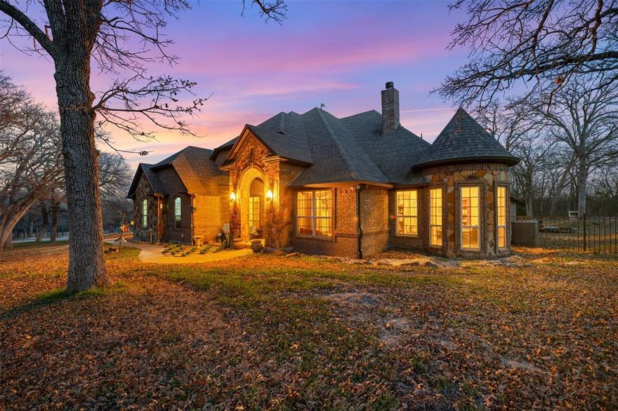 Located in the rolling hills just outside Fort Worth, Lazy JH Ranch offers a rare balance of refined luxury and authentic Texas ranch living. Ideally positioned halfway between Fort Worth and Weatherford, the property provides privacy with the convenience of a 20-minute drive to either. Spanning just over 10 ag-exempt acres, the land is currently home to Longhorn cattle and suited for those who value space, privacy, and legacy ownership.

The one-family-owned primary residence features 5 bedrooms and 3.5 baths, including a mother-in-law suite and a versatile fifth bedroom ideal as a second office. A dedicated office showcases antique double doors imported from India, setting the tone for the craftsmanship throughout. With 14-foot ceilings, 9-foot doors, plantation shutters, and walk-in closets in every bedroom, the home feels expansive yet intentional.

At the heart of the home, the chef’s kitchen features an exotic granite island, custom copper sink, alderwood cabinetry, commercial-grade double oven, and a butler’s pantry perfect for entertaining. 

Walk outside through your oversized double sliding doors to a covered patio framing a resort-style saltwater gunite pool with a stone fireplace and fully equipped gas-plumbed outdoor kitchen. The pool was recently resurfaced and all pumps replaced in 2025, and a pool-accessible bath adds additional convenience.

The guest house offers complete independence with 1 bedroom, 1 bath, laundry, a full kitchen with stainless steel appliances and granite countertops, and a stone wood-burning fireplace. An oversized three-car garage doubles as a workshop with 220V power, totaling five garage spaces. Cross-fenced acreage includes a hay barn ideal for horses or future agricultural use.

Signature details—such as the pair of 400-pound Texas stars reclaimed from a federal building in Houston—underscore the property’s character. Lazy JH Ranch is a statement of Texas heritage, elevated living, and enduring land ownership.