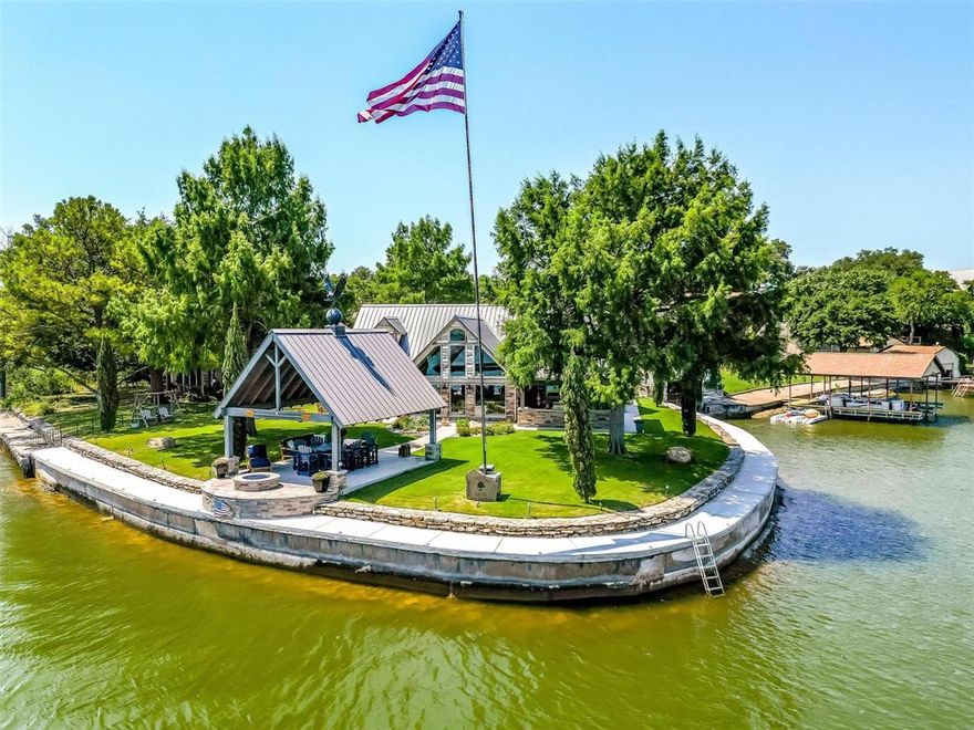 This one-of-a-kind showcase property is situated on a point w 180° views of deep, open water less than 10 mins to Historic Granbury downtown! Fully gutted to the studs in '19, this property was meticulously designed inside & out w no expense spared including all Pella windows & doors & fully spray foamed. The layout is perfect for serene daily living & entertaining w the open concept great room featuring sky high ceilings & windows, chef's kitchen, 2 first floor primary suites, well-equipped outdoor kitchen, & lakeside covered patio w firepit. The pecky cypress walls & reclaimed hand hewn beams give the interior a warm, custom feel. Canopied w mature cypress trees, the entire lot is pristinely manicured & irrigated. Well-built retaining wall & sidewalk around all waterfront. Garage (currently a DREAM man cave) is spray foam insulated & climate controlled. The boat garage includes door at the water, lift & add't storage. Oversized carport + driveway give parking for 12+. AirBNB allowed!