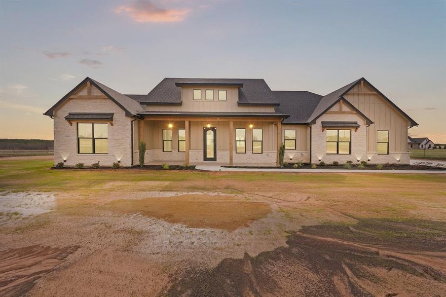 Welcome to this stunning custom-built home situated on over  6 beautiful acres in Godley, Texas, offering the perfect blend of luxury, space, and peaceful country living.
Step inside to an impressive open-concept living, kitchen, and dining area featuring vaulted ceilings with exposed wood beams, a floor-to-ceiling stone fireplace, and large windows that fill the home with natural light while showcasing the surrounding countryside.
The chef’s kitchen is designed for both entertaining and everyday living with a large island, quartz countertops, custom cabinetry, farmhouse sink, high-end gas range, pot filler, built-in microwave, and spacious walk-in pantry.
The thoughtfully designed floor plan provides three bedrooms and 2.5 bathrooms, including a private primary suite with a large walk-in closet, dual vanities, soaking tub, and separate shower. Secondary bedrooms offer generous space and convenient bathroom access.
Additional highlights include:
• Expansive open living area with wood flooring
• Oversized kitchen island perfect for gatherings
• Large laundry room with built-in storage
• Dedicated pantry and utility spaces
• Oversized garage
• Covered front porch ideal for enjoying peaceful Texas sunsets and back porch with fireplace to enjoy during colder weather
Located in Godley ISD, this property offers the perfect opportunity to enjoy country living with room for animals, a shop, or future outdoor amenities while still being a short drive to town.
If you're looking for space, privacy, and a beautifully designed home, this property delivers it all.