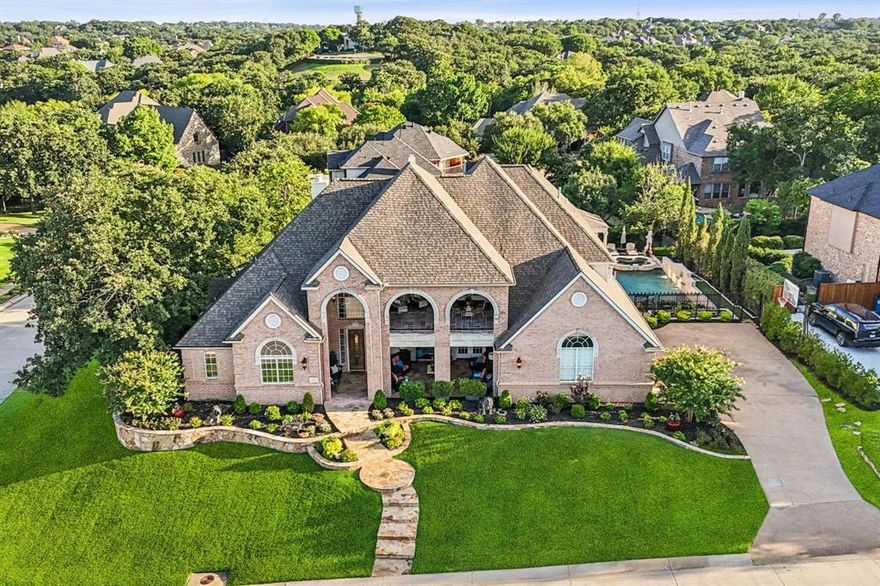 This exquisite estate in the highly sought-after community of Highland Shores is a true standout, offering elegant curb appeal with manicured landscaping, a charming front porch, and an upper-level balcony perfect for morning coffee or evening relaxation. A grand foyer with soaring ceilings, a statement chandelier, and gleaming hardwood floors sets the tone for the sophisticated design throughout. Just off the entry, a spacious private study provides the perfect work-from-home retreat, while the formal living room impresses with double-height windows, a grand fireplace, and an abundance of natural light. The formal dining room is designed to host elevated dinner parties with grace and style. At the heart of the home, the gourmet chef’s kitchen features granite countertops, a raised breakfast bar, center island, stainless steel appliances including a wine fridge, and a built-in planning station in the sunny breakfast nook. The adjacent family room offers vaulted ceilings, a second fireplace, and custom built-ins, creating an inviting space for everyday living and entertaining. The luxurious primary suite is a peaceful haven with a private sitting area and a spa-like bath showcasing dual vanities, jetted tub, separate shower, framed mirrors, and a generous walk-in closet. One of the home’s most unique features is the expansive in-law suite, complete with a full second kitchen, spacious living area, and private bedroom suite—ideal for multi-generational living or long-term guests. Upstairs, a large balcony provides a stunning outdoor entertaining space, while the backyard is a true sanctuary, featuring a resort-style pool and spa, mature trees for privacy, and a wraparound lawn that feels like a private park. A well-appointed utility room with built-ins and sink, generous guest bedrooms, and thoughtful finishes throughout complete this exceptional home—offering both elegance and functionality in one of the area’s most prestigious neighborhoods.