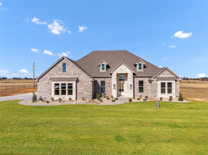 Set on 2 acres in Rolled Stone Estates in Tolar, this beautifully crafted 2,504 square foot home blends refined design with wide-open Texas living. From the striking stone and brick exterior to the thoughtful interior finishes, every detail feels intentional.

Inside, the living room is anchored by a gas fireplace with floor-to-ceiling tile surround and custom built-in cabinetry on both sides, creating a stunning focal point with warmth and symmetry. LVP flooring flows throughout the home, complemented by black plumbing and lighting fixtures that add a modern, cohesive look.

The kitchen is both functional and show-stopping, featuring quartz countertops, KitchenAid appliances, built-in microwave, and a large center island ideal for gathering. A spacious butler’s pantry offers exceptional storage and prep space with a second dishwasher and a beverage refrigerator, making entertaining effortless. 

The primary suite offers a peaceful retreat with a spa-inspired bathroom showcasing a standalone soaking tub, walk-in shower, and elevated finishes. All 3 secondary bedrooms include walk-in closets, providing generous storage throughout. A dedicated office offers flexibility for working from home or additional living space. A half bathroom near the generous laundry room offers convenience for all.

Additional highlights include a 2-car garage with stairs leading to attic storage, expansive windows that bring in natural light and countryside views, and acreage with endless potential for outdoor living, a shop, or future additions. This property offers the perfect balance of luxury finishes and relaxed rural living in a sought-after Tolar community.