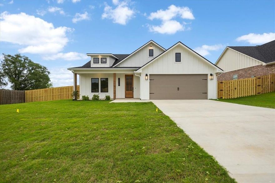 Located in The Crossings at Mission Ridge, this 5-bedroom, 2.5-bath home in Lindale ISD offers peaceful living with
sidewalks, a stocked fishing pond, and no HOA. The main level features four bedrooms with each guest bedroom offering a
generously sized closet. The kitchen impresses with perfectly stained cabinets, an island, stunning stone backsplash, a gas
cooktop, and an upgraded KitchenAid appliance package. The living room is a true showstopper with vaulted ceilings and a
floor-to-ceiling stone wood-burning fireplace that creates a warm and inviting focal point. The master suite offers seamless
access from the laundry room to the primary closet to the primary bathroom, which features a tiled walk-in shower and a
separate soaking tub. Upstairs, a fifth bedroom or bonus room adds flexibility. Outside, enjoy a large fenced yard and outdoor
kitchen, perfect for entertaining!