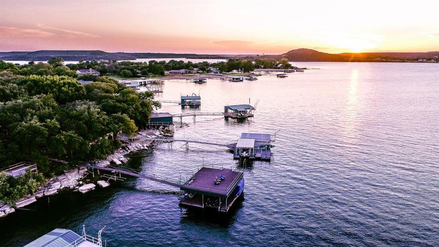 Escape to your own HIDDEN RETREAT! As you meander off the main road toward the entrance gate, the stress of daily life effortlessly fades away. Step onto the lush St.Augustine grass under the shade of towering trees & follow the enchanting pathway to the lakeside to discover a private dock extending over the deep blue waters of Possum Kingdom Lake, evoking a carefree sense of childhood camp days. Inside this exquisite haven, experience a serene spa-like atmosphere, set against lofty ceilings that beckon you to unwind in front of the fireplace, while walls of windows invite the breathtaking scenery indoors. The interior boasts a blend of comfort & sophistication, featuring Lentz lighting, Ann Sacks tile flooring throughout, & a clear, crisp aesthetic that creates an ideal space to RELAX & ENJOY! This retreat is complete with open-concept design, SS appliances, air filtration system & double deck dock. Indulge in the perfect fusion of tranquility & convenience – this property has it ALL!