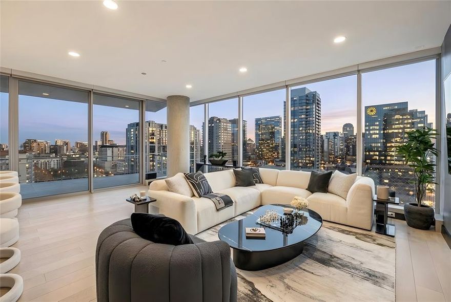 Perched high above the Harwood District, this exceptional Bleu Ciel residence captivates with uninterrupted, floor-to-ceiling views framing the glittering Dallas skyline from every room. The wraparound terrace offers multiple seating areas and a sleek outdoor fireplace, creating a private sanctuary suspended in the sky. Inside, the open-concept living space is wrapped in glass, flooding the home with natural light and showcasing striking modern finishes. The designer kitchen features custom Porcelanosa cabinetry, marble countertops, integrated Miele appliances, and a sculptural island perfect for entertaining against a dramatic skyline backdrop. A dedicated media room adds a luxurious retreat, while the serene primary suite feels like a five-star hotel with its panoramic views, spacious layout, custom California Closet system, and spa-inspired bath. Here, a freestanding soaking tub, oversized marble shower, and illuminated niche detailing create a true wellness experience. Sleek hardwood floors, refined lighting, an effortless flow, and over $100,000 in upgrades elevate the home’s sophistication throughout. Residents of Bleu Ciel enjoy unmatched amenities: two junior Olympic-sized pools with cabanas, a poolside chef’s kitchen, full-service spa, private wine lounge with storage, two boardrooms with advanced AV, a contemporary library lounge, private garages, a state-of-the-art fitness and yoga center, pet park, and 24 hour valet and concierge. Experience the best of sky-rise living—luxury, privacy, and breathtaking views—all in one extraordinary home.