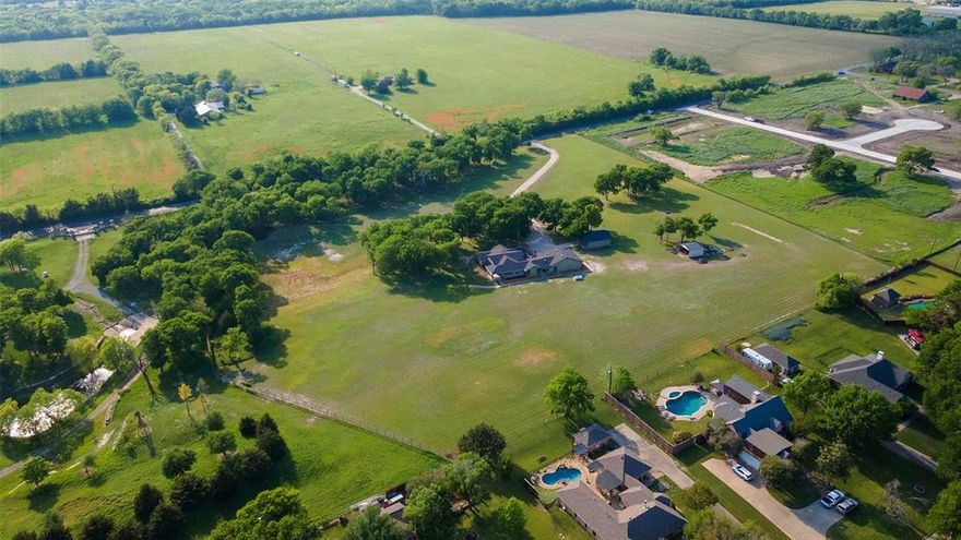 Prime Investment or Private Estate Opportunity in Melissa! This stunning 10-acre property on Miller Road offers incredible versatility, whether you're looking for a future development investment or a private estate. The 2,466 sq. ft. custom home, built in 2011, has been immaculately maintained and presents as much newer. It features two bedrooms, an office, 2.5 baths, beautiful light new wood flooring, modern cabinetry, and energy-efficient amenities such as two tankless water heaters and spray foam insulation. The home also includes a warrantied septic system and an expansive 1,000+ sq. ft. three-car garage with a designated car detailing area.

In addition to the home, the property includes a 30’ x 24’ workshop with 24 feet of workbench space plus an additional 4’ x 10’ workbench island. A garage door allows access to one car bay, with the potential to modify for two. There is also a three-sided metal storage barn, perfect for equipment or livestock needs. The wildlife exemption on nine acres offers a tax advantage, and mature trees line the front of the property, adding to its charm.

Surrounded by well-developed high-end estate properties, this land is ideally situated. To the north, a 12-acre multi-home estate is under development, while the two neighboring estates to the south (20 and 30 acres) each feature multiple well-appointed homes. The location is unbeatable, just minutes from Hwy 121 and Hwy 5, providing both convenience and privacy.

Whether you choose to live in the existing home and enjoy the space, build an additional home or two, or lease the property and hold it for future development, the possibilities are endless. Don't miss this rare opportunity.