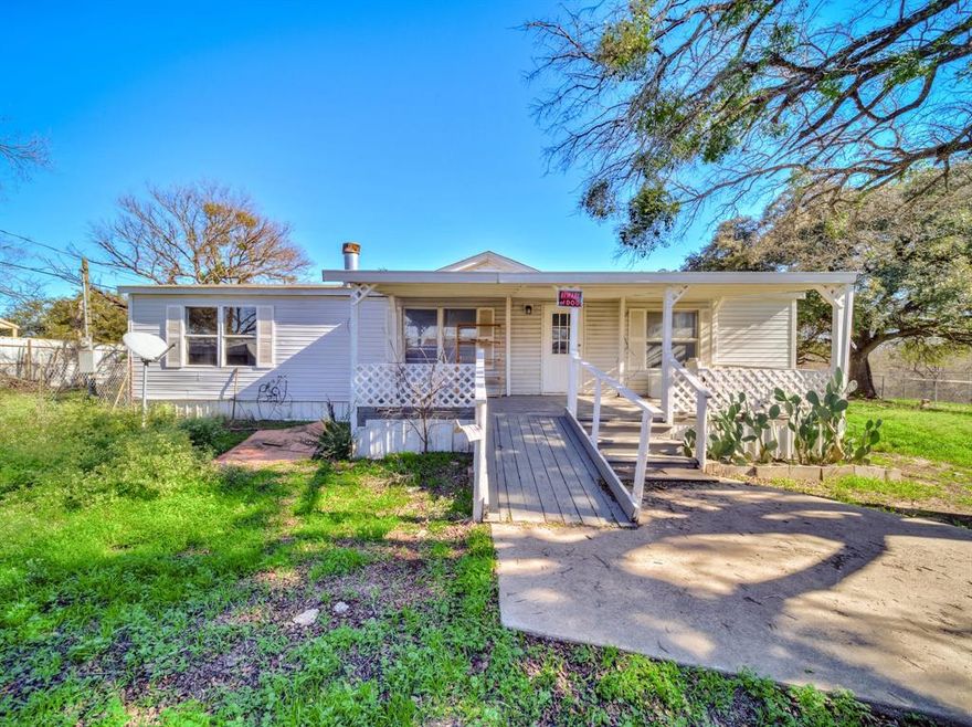 Sitting just outside the hustle and bustle of city life,  3-bedroom, 2-bath double-wide mobile home that sits on a HALF acre! 3 NEW storage buildings (24x12,10x7 & 12x9) a 2 car carport, hay barn & storm shelter. The heart of the home is the large open kitchen, Featuring an engaging kitchen island, double sinks, ample cabinetry, granite countertops & stainless steel appliances.  A separate full size utility room located off the kitchen. Each spacious bedroom boasts walk-in closets, ceiling fans & have split bedrooms. Living room has your cozy wood burning fireplace with decorative wood paneling. Large master bedroom with new carpet and a walk in closet. Master bathroom has separate shower and bathtub, granite countertops & double sinks. 
Step outside to enjoy the expansive covered porches—both front and back, each measuring 35ft x 11ft—perfect for sipping morning coffee or hosting evening gatherings.
Outdoors, you'll discover a world of possibilities! THREE NEW storage buildings (24x12, 10x7, and 12x9) provide plentiful space for tools, toys, or hobbies along with A two-car carport for parking.  Your property is completely fenced and cross-fenced and has shade trees allowing for peace of mind whether you’re entertaining guests or relaxing. Experience the charm of country living with all the modern comforts you desire. 
UPDATES INCLUDE: Carpet in master bedroom, freshly painted back porch, new septic lines, hot water heater, HVAC, breaker panel, electric pole has new wiring, tile and laminate flooring, granite countertops & storage buildings. BRING AN OFFER!