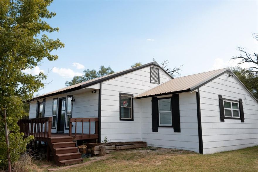 Enjoy a quiet neighborhood and views of the lake from the spacious deck on the front of this completely refurbished 3 BR 2 Bath home.   Everything is new including the central heat and air unit, plumbing, electrical, flooring, counters and more.   The metal roof is in great shape so was not replaced.  The main bedroom and ensuite are a garage conversion and feature two closets, double sinks and a jetted soaker tub.  The kitchen opens up into the living and dining area separated by a breakfast bar.  This home is bright and cheery with lots of natural light.  There is plenty of room to spread out on almost half an acre which features mature trees and a storage building.  The landscaping possibilities are endless to make it your own.  Seller is planning to install an electric gate in the decorative metal fence in the front for added privacy.  Come and take a look at this little gem!