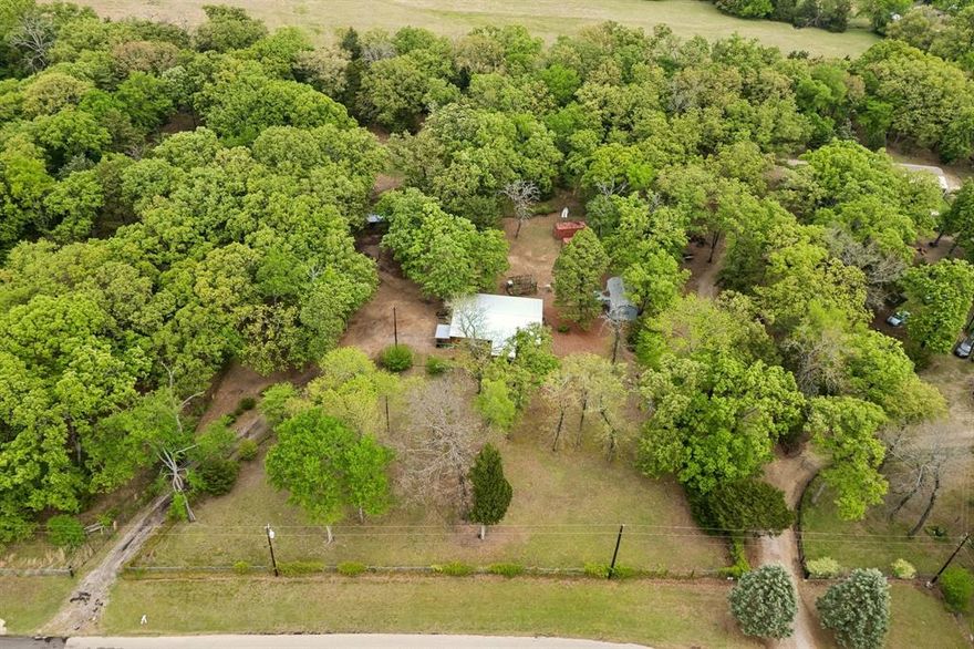 Nestled on 5 beautifully wooded acres, this peaceful country retreat offers the perfect blend of privacy, charm, and convenience. The property is filled with mature native oaks, cedars, and pines, creating a serene, natural setting you’ll never want to leave.
The cozy single-wide home features 2 bedrooms, 1 bath, and an inviting eat-in kitchen. Enjoy quiet mornings on the screened-in front porch or unwind in the spacious second living area addition. A covered rear deck provides the ideal spot for relaxing or entertaining while taking in the tranquil surroundings. A single carport adds everyday convenience.
A standout feature of the property is the charming secondary structure, affectionately known as the “Quilt House.” Complete with a half bath, it offers endless possibilities—perfect for hobbies, a workshop, guest overflow, or additional living space.
The land also includes two barn structures, making it ideal for storage, projects, or embracing a more rural lifestyle.

Despite its private, tucked-away feel, this property is located just minutes from downtown Canton and the renowned First Monday Trade Days, giving you the best of both worlds—peaceful country living with easy access to shopping, dining, and events.

Whether you’re looking for a weekend getaway, a full-time slower-paced lifestyle, or the perfect site to build your future dream home, this property is full of opportunity and potential.