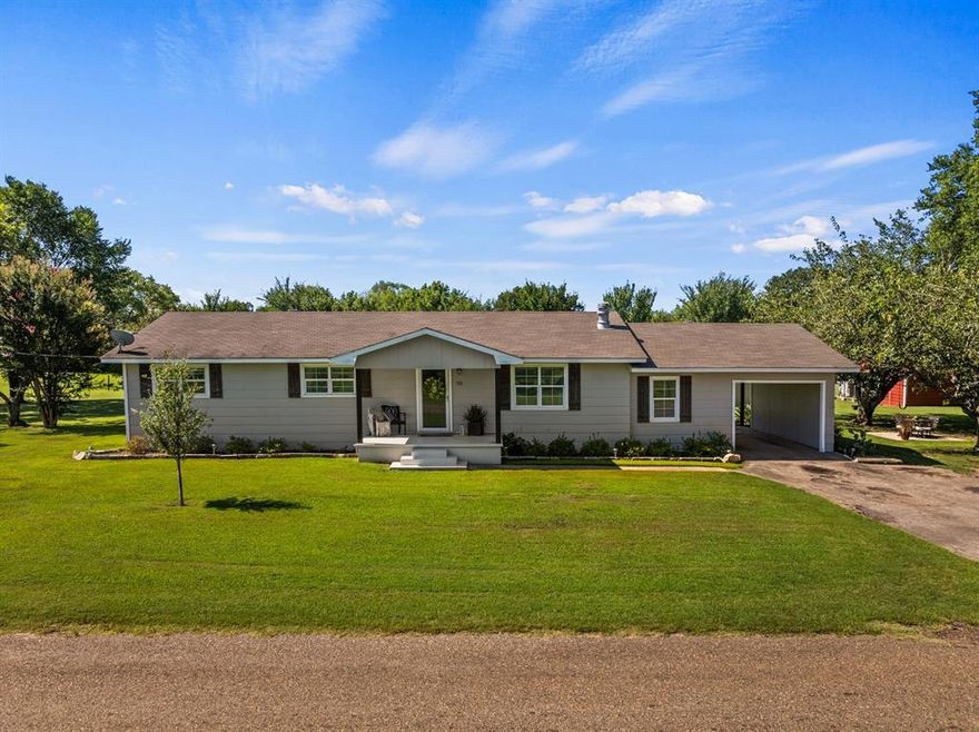 This property provides a tranquil setting ideal for individuals seeking residence just outside the city limits or those desiring a peaceful environment to raise a family. Imagine watching your horses run in the mornings while sipping coffee on the spacious back porch. This property overlooking 2.21 acres features 1,636 sq ft with three bedrooms and two full bathrooms. The living room is highlighted by a substantial rock fireplace, serving as a central focal point. The combined dining and kitchen area offers granite countertops, extensive cabinetry, a pantry area and washer and dryer connections that allows for direct carport access. Additional interior details include plank flooring, neutral paint tones, a barn door, and a distinctive accent wall. The expansive grounds accommodate a variety of uses, whether for gardening, animal care, or recreation, seamlessly blending rural appeal with contemporary comforts. Outdoor amenities include a 560 sq ft metal shop equipped with electricity and two additional outbuildings suitable for multiple purposes. Conveniently located minutes from Mt. Vernon ISD and downtown, the property affords easy access to local dining, shopping, and entertainment venues. Recreational opportunities such as Lake Cypress and Bob Sandlin are also nearby, providing options for fishing and other outdoor activities. Schedule a tour to experience everything this property has to offer.