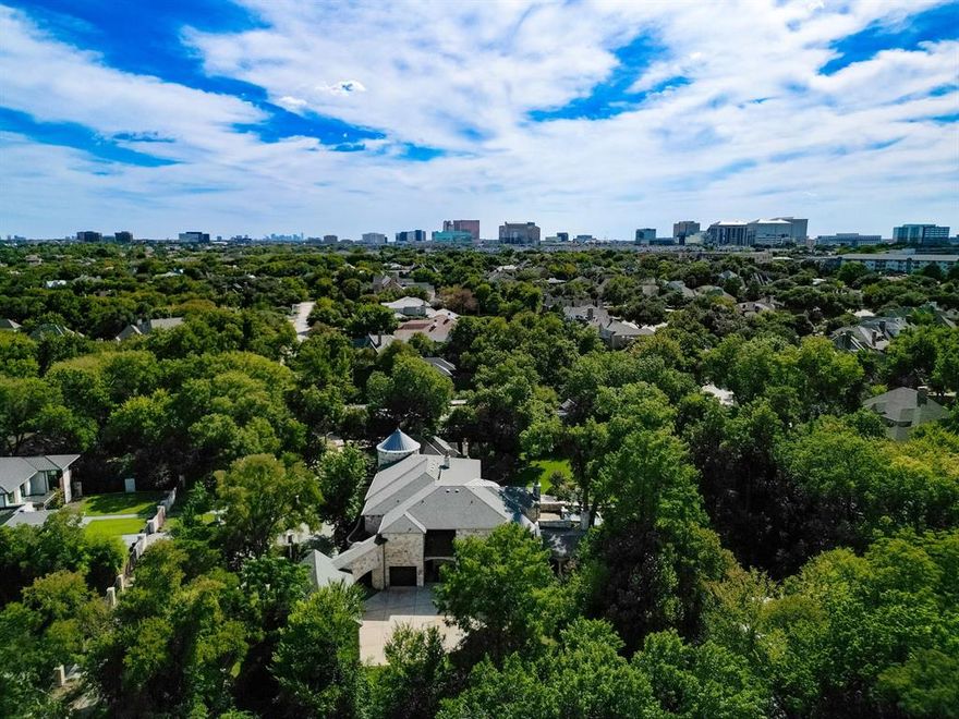 Majestic luxury in cul-de-sac home full of custom features, including private pond & fountain, energy-efficient features, elevator, and custom design touches. Grand entry wows with dramatic iron staircase and vaulted ceilings that show off gold inlay turret with chandelier. Huge dining room with French doors to front veranda, custom ceiling mural, and access to 750-btl temp-controlled wine room. Formal living features floor-to-ceiling UV-protected windows overlooking outdoor retreat, Isokern fireplace, and onyx-topped bar with 2 Uline fridges. Expansive gourmet kitchen includes 2 Bosch dishwashers, Viking 6-burner gas cooktop, double ovens, warming drawer, & massive island. Oversize walk-in pantry offers 2nd built-in fridge and extra storage. Stylish study has French doors to front patio and hidden room used as storm shelter. Primary suite feels like a luxury hotel, with imported wood doors from Bali, coffee bar & refrigerator, and elegant fireplace in sitting area. Spa-like primary bath with exquisite hand-carved marble tub, walk-in shower with dual heads, dual vanities, heated travertine flooring, and walk-in closet with island. Expansive game room offers space for pool table or gaming, with access to large balcony overlooking lush outdoors. Theatre includes ample seating and refrigerator for movie nights. Spacious exercise room fits machines & weights with access to steam shower bathroom. Secondary bedrooms have full baths & walk-in closets, and can be extra office or craft space. Expansive covered patio is ideal outdoor living, with built-in kitchen, fireplace, misting & mosquito systems, and room for seating & dining. Exquisite heated pool overlooks verdant yard with firepit, private pond, and fountain. Additional features include Infinity Carrier HVAC system, gated driveway & sport court, and upstairs 2nd laundry room. Close proximity to top-tier dining, entertainment, and golf courses.  Conveniently located to Dallas’ top private and collegiate prep schools.