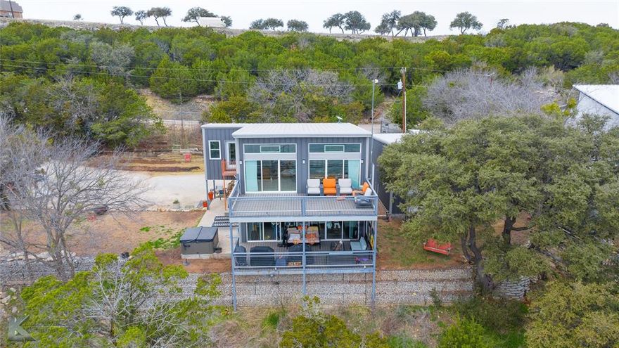 WATERFRONT HOME WITH EFFICIENCY APARTMENT!  This stunning 2 bedroom 2 full bath multi level home with small efficiency apartment over garage has it all!  Modern design with industrial touches add charm and character to this waterfront property on gorgeous Possum Kingdom Lake.  Main and second level decks offer unobstructed views for sunrise morning coffee or peaceful lake nights. There is a wealth of natural light and breath taking views from primary bedroom, living room, and kitchen area. Primary bedroom has coffee bar with LG tower washer dryer combo.  Second bedroom has Murphy bed with storage for hanging clothes.  EXTRA BONUS is the 450 Sq. ft. multi level Efficiency apartment in garage. Private path to boat dock with custom made furniture for lake living at its best. Dock boast 2 slips with electric boat lift and hydro hoist, a jet ski dock and mooring whips to facilitate guest boats. Dock also has attached light for off the dock night fishing.  Don't miss out on this piece of paradise!  Enjoy the view and quiet slower paced side of PK Lake.  CLICK ON VIRTUAL AND VIEW YOUTUBE DRONE VIDEO!