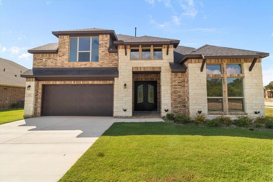 East Fort Worth gorgeous new build is loaded with style, space, modern features, open living space with soaring ceilings, a dramatic curved staircase, and a sleek, contemporary layout. Great floor plan with 2 bedrooms downstairs and 2 upstairs. Exterior up-lighting, a large 6'x8' Iron Double Front Door, 3 security cameras, and a tankless hot water heater. The chef’s kitchen shines with granite countertops, a gas stove, rich dark cabinetry with LED lighting, stainless steel appliances, and a huge island that flows into the light-filled living room with a bold floor-to-ceiling tiled gas fireplace. The luxe primary suite offers a spa-like escape with dual vanities, a soaking tub, and a walk-in shower. The utility room is connected to the master closet. Upstairs, enjoy a spacious game room that overlooks the main floor—perfect for movie nights or entertaining. Step outside to the corner lot with a fully fenced backyard with mature trees and plenty of room to play or relax. With top-tier curb appeal, energy-efficient construction, and a prime Fort Worth location, this home is the total package. 1-year builder warranty.