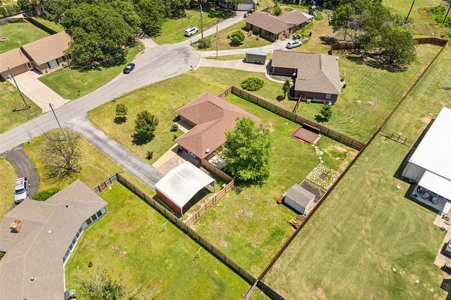 Tucked away at the end of a quiet cul-de-sac with mature trees,a beautifully maintained single-story home perfectly balances comfort, style, and flexibility. Situated on an oversized lot, there’s plenty of room to create your dream backyard oasis—add a sparkling pool, a workshop, or just enjoy the wide-open space. From the inviting front patio to the long driveway and lush front lawn, the curb appeal is undeniable. Inside, you’ll be greeted by a warm and welcoming living area with vaulted, beamed ceilings and plush carpet, flowing effortlessly into the formal dining space and a tastefully updated kitchen. The kitchen is a true highlight with granite countertops, shaker-style cabinets, a center island with raised breakfast bar, stone backsplash, and a built-in planning station—ideal for today’s busy lifestyle. This thoughtfully designed home features three spacious bedrooms, including one with a private exterior entrance—perfect for a home office, guest suite, or hobby space. The primary suite offers a peaceful retreat with its own private bath. Step outside to an expansive backyard that’s ready for anything—whether it’s entertaining, gardening, or relaxing under the large covered patio. Additional upgrades include a new water heater (2023), updated HVAC, new fencing, septic risers, and French drains for added peace of mind. Don’t miss your chance to own this versatile, move-in-ready gem in a serene Krugerville-Aubrey neighborhood-Minutes from downtown Aubrey and all the fun events they put on for the town! Schedule your private tour today!