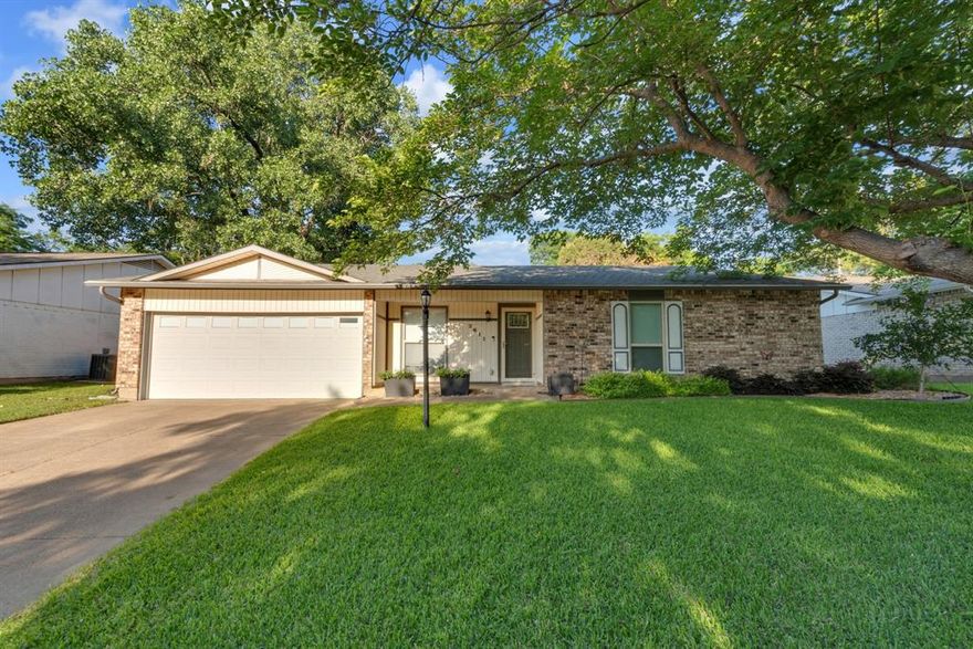 Welcome to this beautifully maintained Arlington gem offering the perfect blend of comfort, character, and outdoor living. From the moment you step inside, you’re greeted by soaring vaulted ceilings with exposed beams, a stunning brick fireplace, and an expansive living area designed for gathering and entertaining. The updated kitchen features crisp white cabinetry, modern backsplash, abundant counter space, and a cozy breakfast nook overlooking the backyard. Spacious secondary bedrooms and a beautifully remodeled primary bath provide both style and functionality, while the flexible bonus room is ideal for a home office, game room, or additional living space. Step outside and enjoy your own private retreat with a large tiered backyard, mature trees, lush landscaping, patio space for entertaining, and plenty of room to relax or play. Nestled in an established neighborhood with easy access to shopping, dining, parks, and major highways, this home offers the lifestyle and space today’s buyers are searching for.