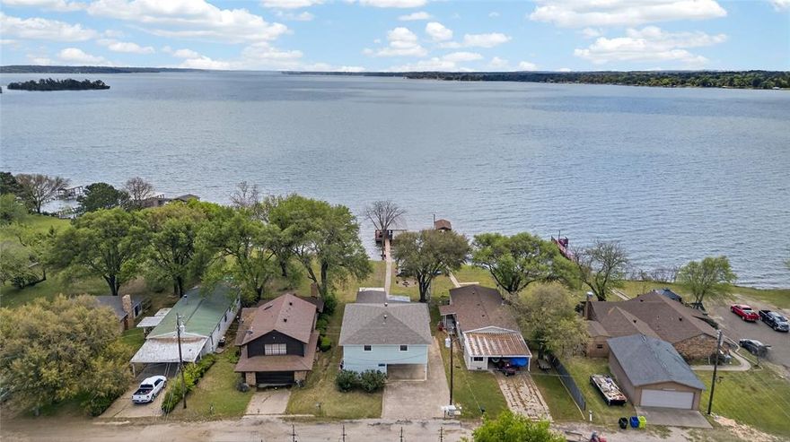 Spacious 4 bedroom, 3 bath waterfront home situated on open water and boasting unobstructed lake views and tons of updates! Upstairs
features two over-sized bedrooms, each with walk-in closets, connected by a large shared bathroom with lighting updated in
2021. Downstairs offers two more bedrooms and two full baths also updated in 2021. The open concept kitchen, flows
seamlessly into the living and dining areas with separate den providing extra space to relax or entertain. The flooring was
upgraded in 2021 to a water proof laminate flooring with moisture barrier for easy maintenance. Also in 2021, the interior was
repainted including kitchen and bath cabinets. Enjoy the outdoors from the covered patio, open deck, or private balcony, all
perfect for taking in the expansive lake views. The exterior enjoyed updating in 2021 with exterior siding, paint, wood repair, a
fire pit was installed, and decking was resurfaced. In 2024, the dock, roof, and sprinkler system were replaced. Additional
updates include rebuilt back flower beds, replaced landscaping, new insulation in the attic, and new kitchen fridge. Property
amenities include a pier with a boathouse, a storage building, and access to a shared community area with a boat ramp and
pier. Originally a mobile home that has been thoughtfully expanded offering a fantastic opportunity as a weekend getaway or
full-time lake residence. Full list of updated items is available.